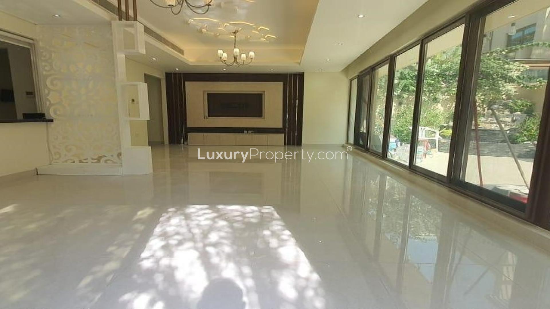 Spacious living area with large windows in elegant Meydan villa for rent