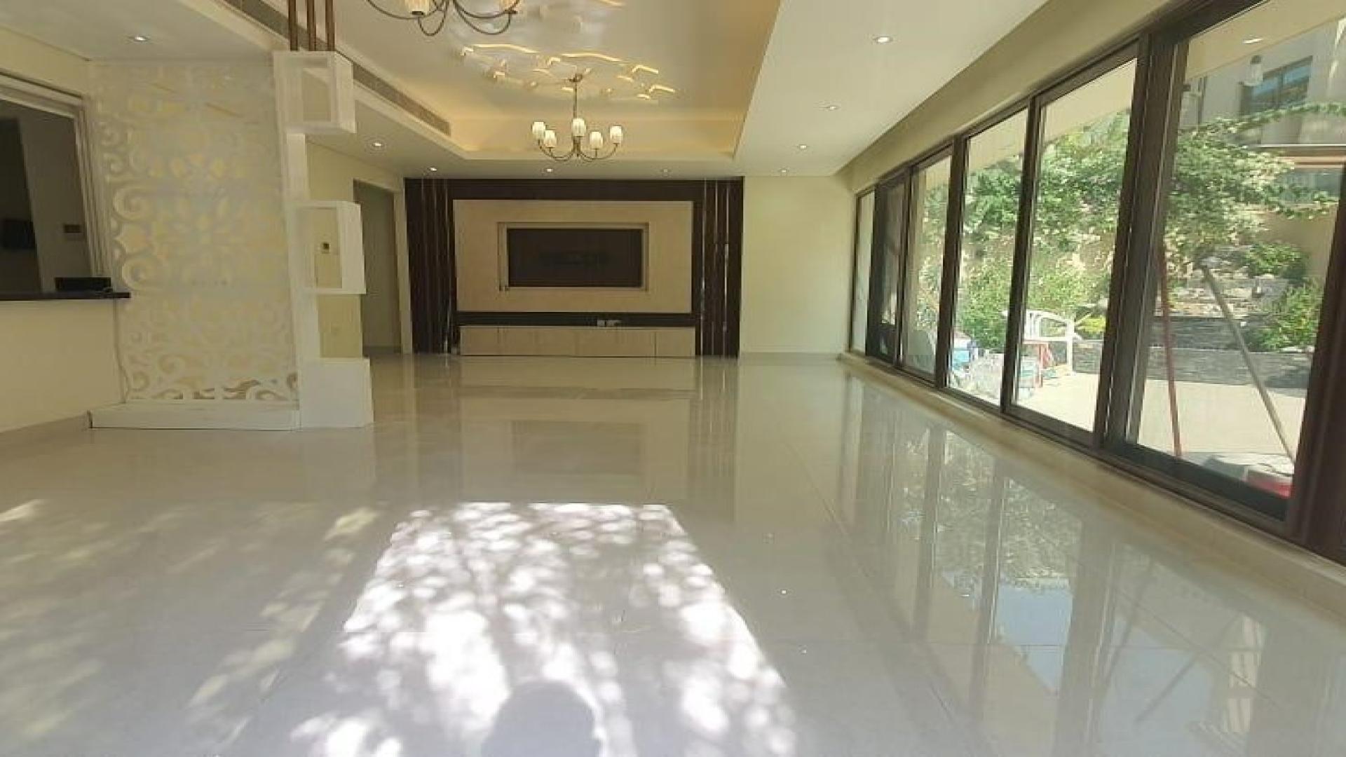 Spacious living area with large windows in elegant Meydan villa for rent