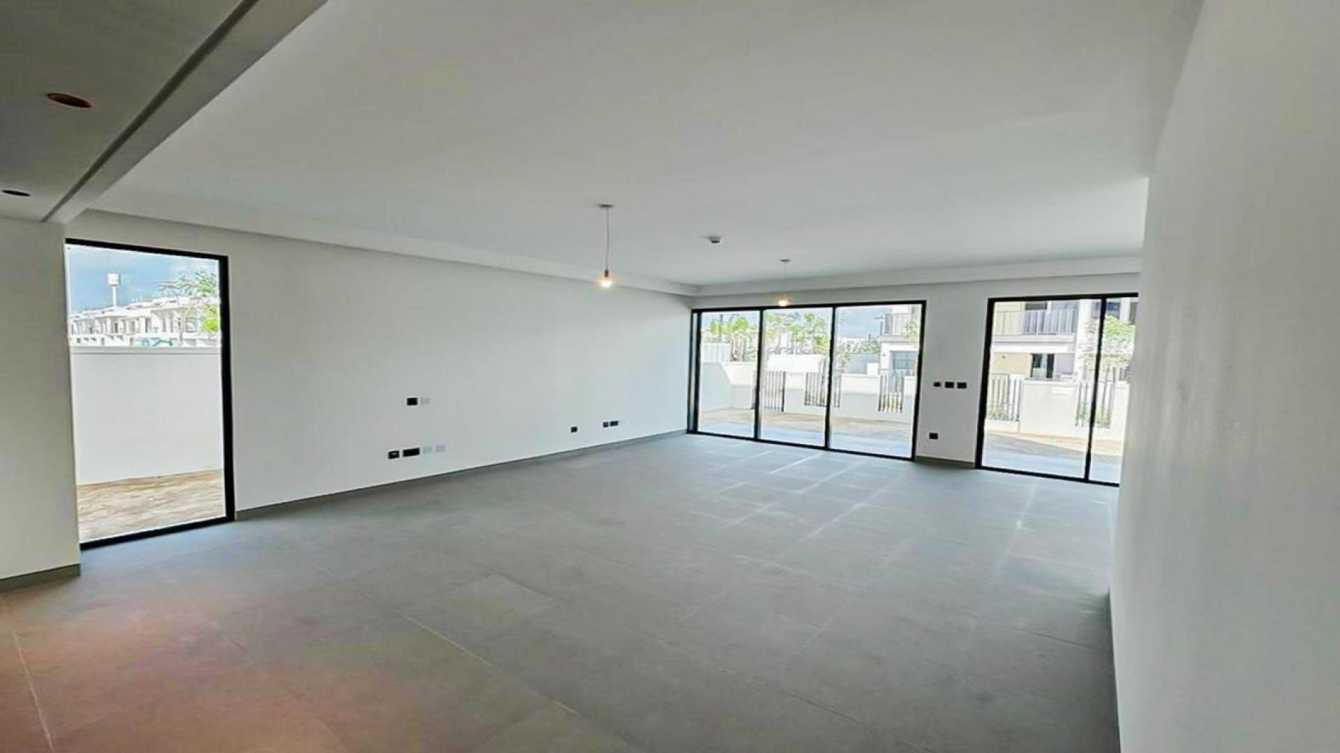 Spacious living room with large windows in Tilal Al Ghaf villa for rent