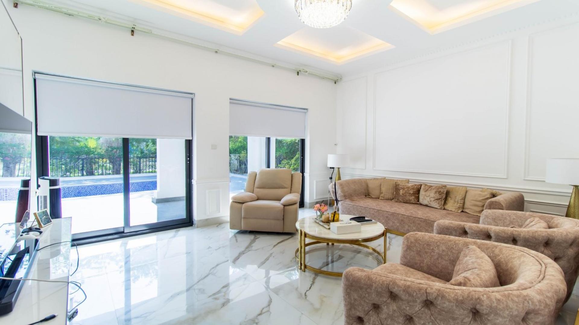 Luxurious sunlit living room in Vastu-compliant Jumeirah Islands villa with garden view