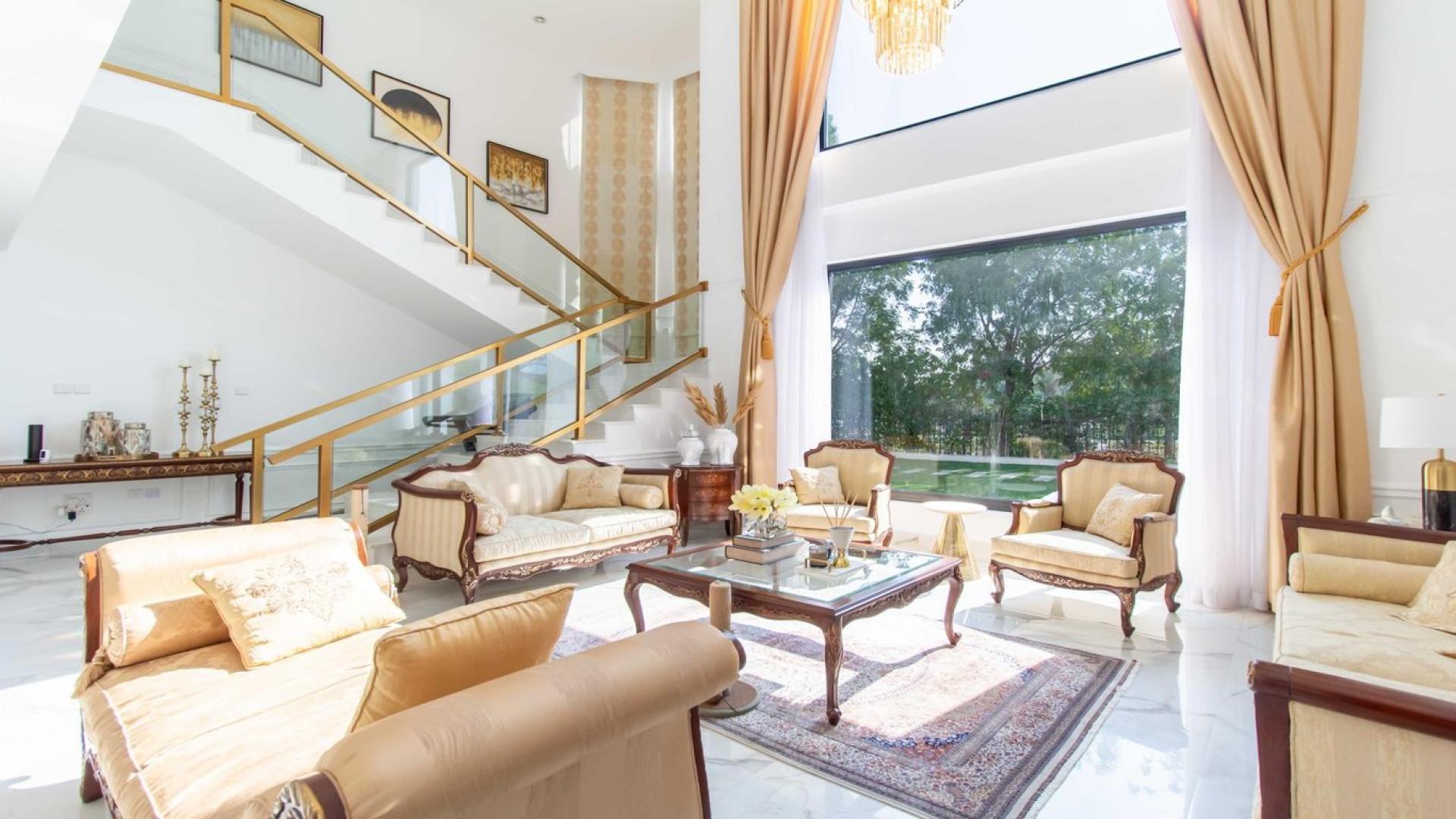 "Elegant villa with pool, lush garden in Jumeirah Islands' Islamic Clusters, available for rent.",Luxurious sunlit living room in Vastu-compliant villa, Jumeirah Islands, with garden view