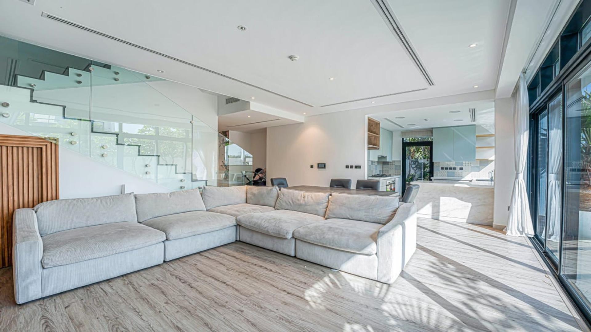 Elegant living room in Jumeirah Golf Estates villa, featuring modern design and pool view