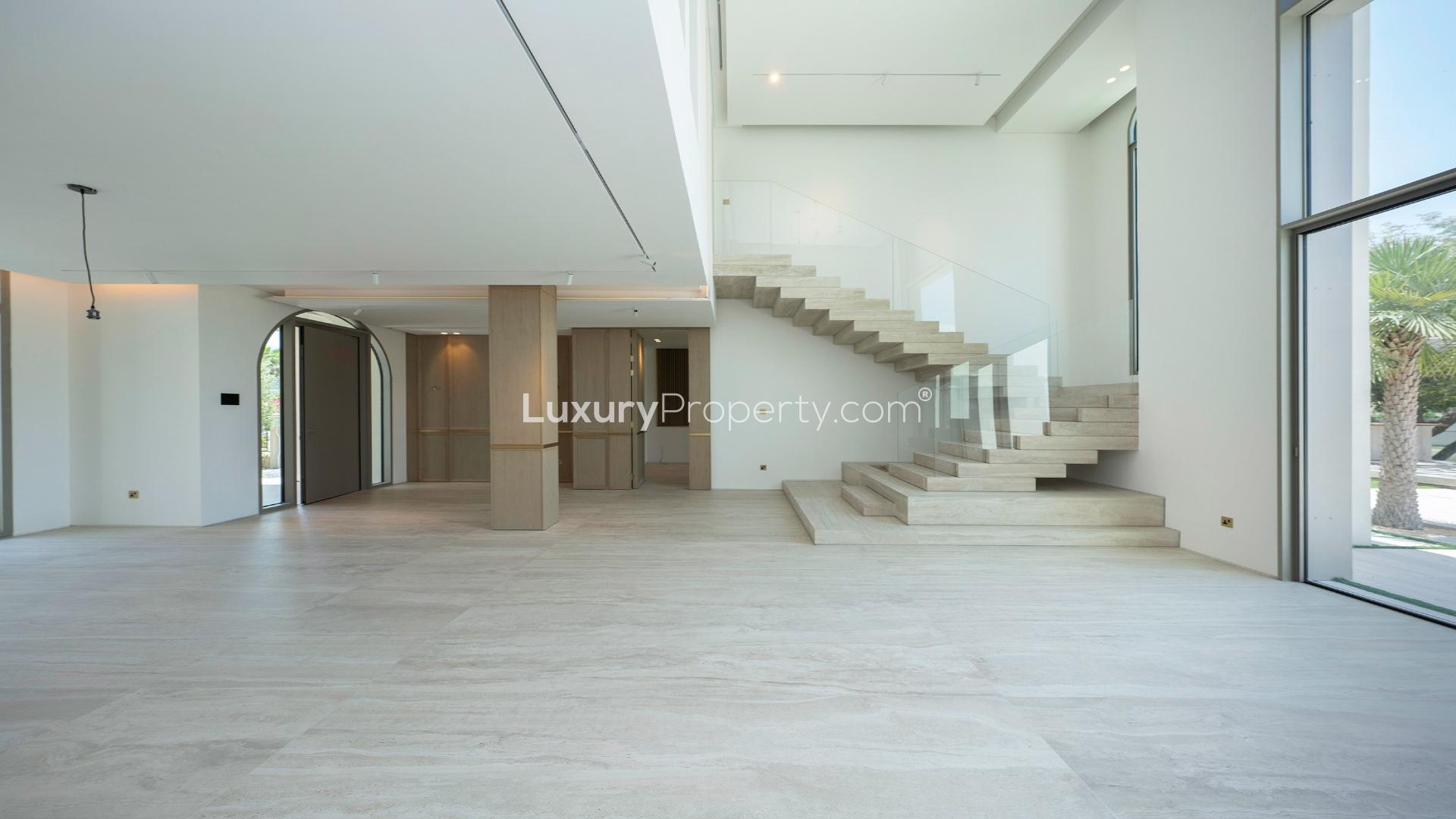 Luxurious villa interior with modern staircase and large windows in Jumeirah Islands