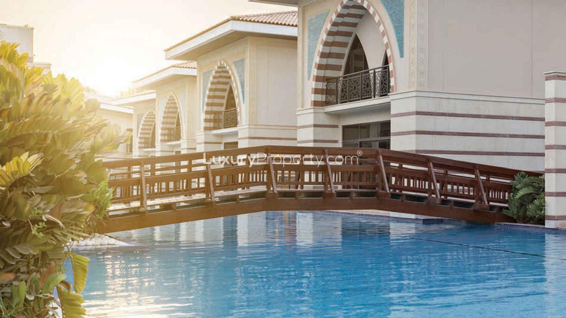 "Elegant four-bedroom lagoon villa exterior with garden on Palm Jumeirah Crescent for sale.","Luxurious lagoon villa with pool on Palm Jumeirah Crescent, four-bedroom for sale.",Luxurious living room in four-bedroom villa, Palm Jumeirah, elegant decor, spacious seating area