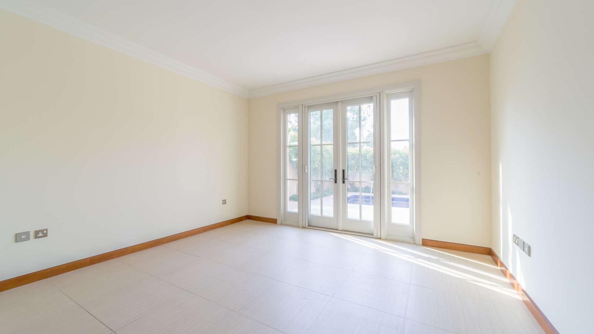 Spacious living room in Jumeirah Golf Estates villa with large windows and elegant columns