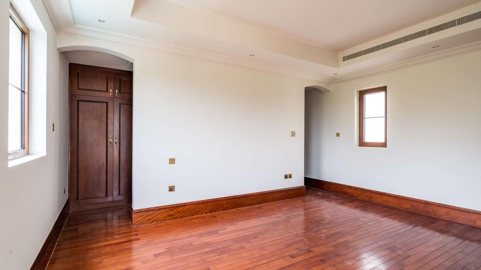 "Spacious living room with pool view in Zaragoza Villa, Jumeirah Golf Estates, Earth community.",Empty bedroom with wooden floors in Zaragoza Villa, Lime Tree Valley, Jumeirah Golf Estates