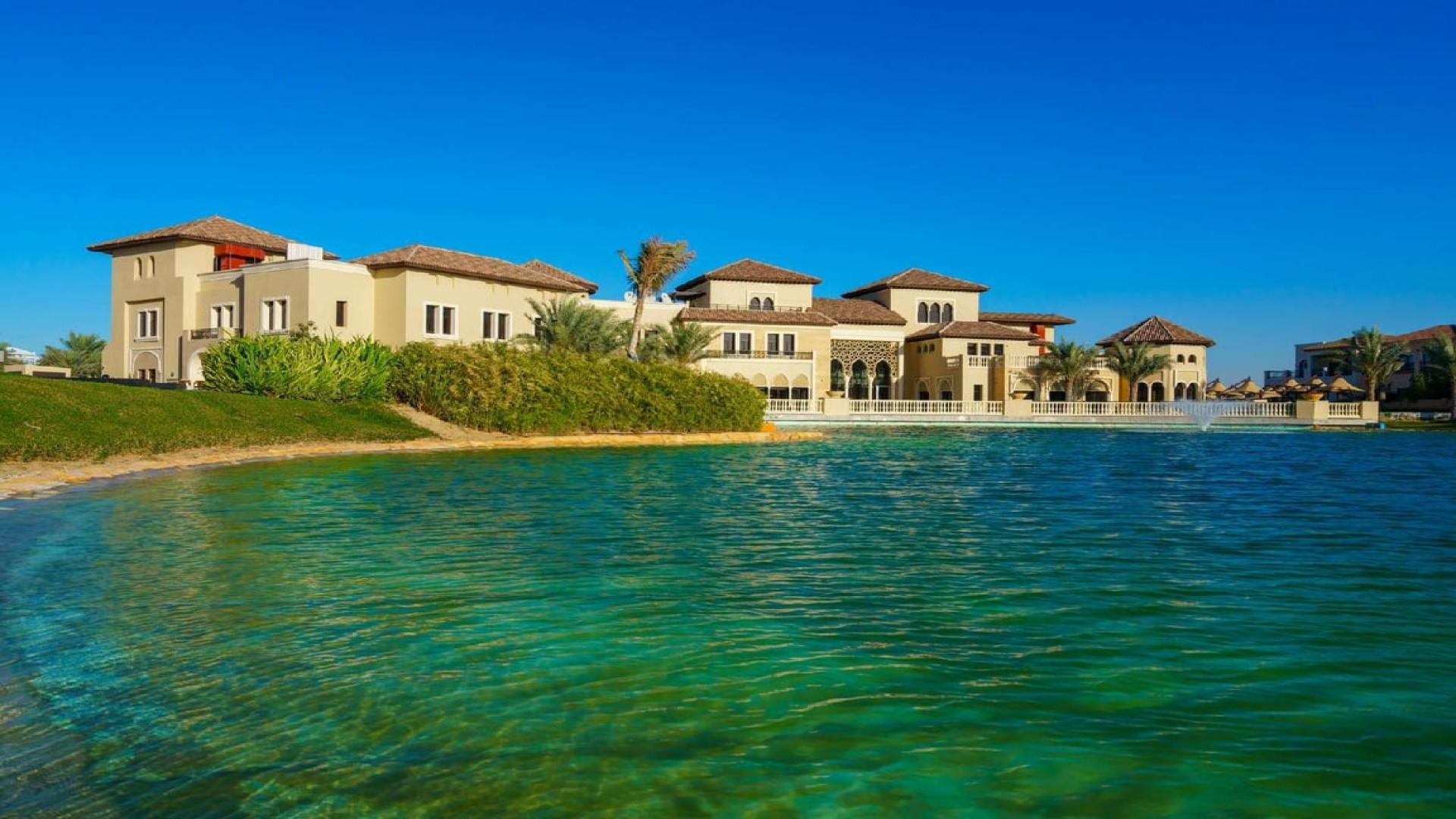Spacious kitchen in four-bedroom villa, Orange Lake, Jumeirah Golf Estates, featuring modern wood cabinetry