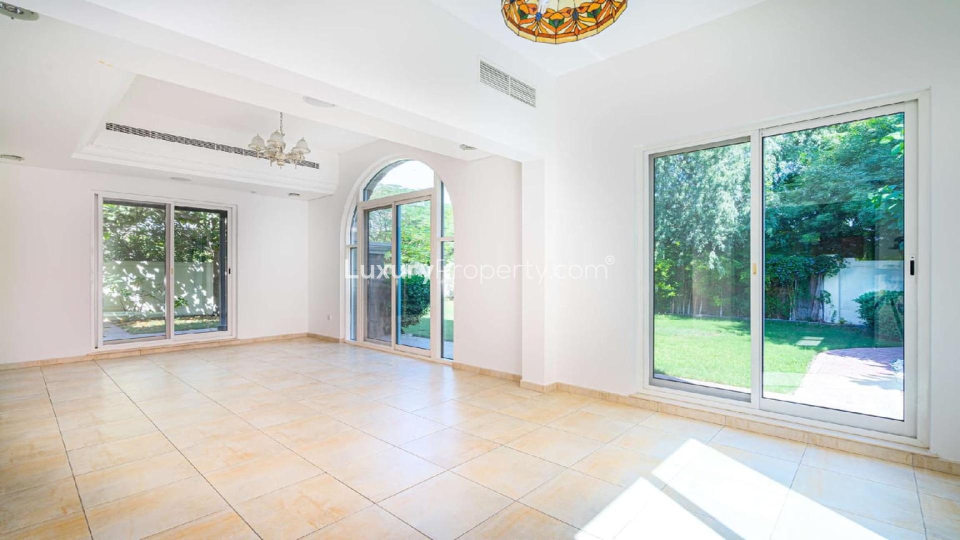 Spacious villa interior with large windows overlooking garden in Victory Heights, Dubai Sports City