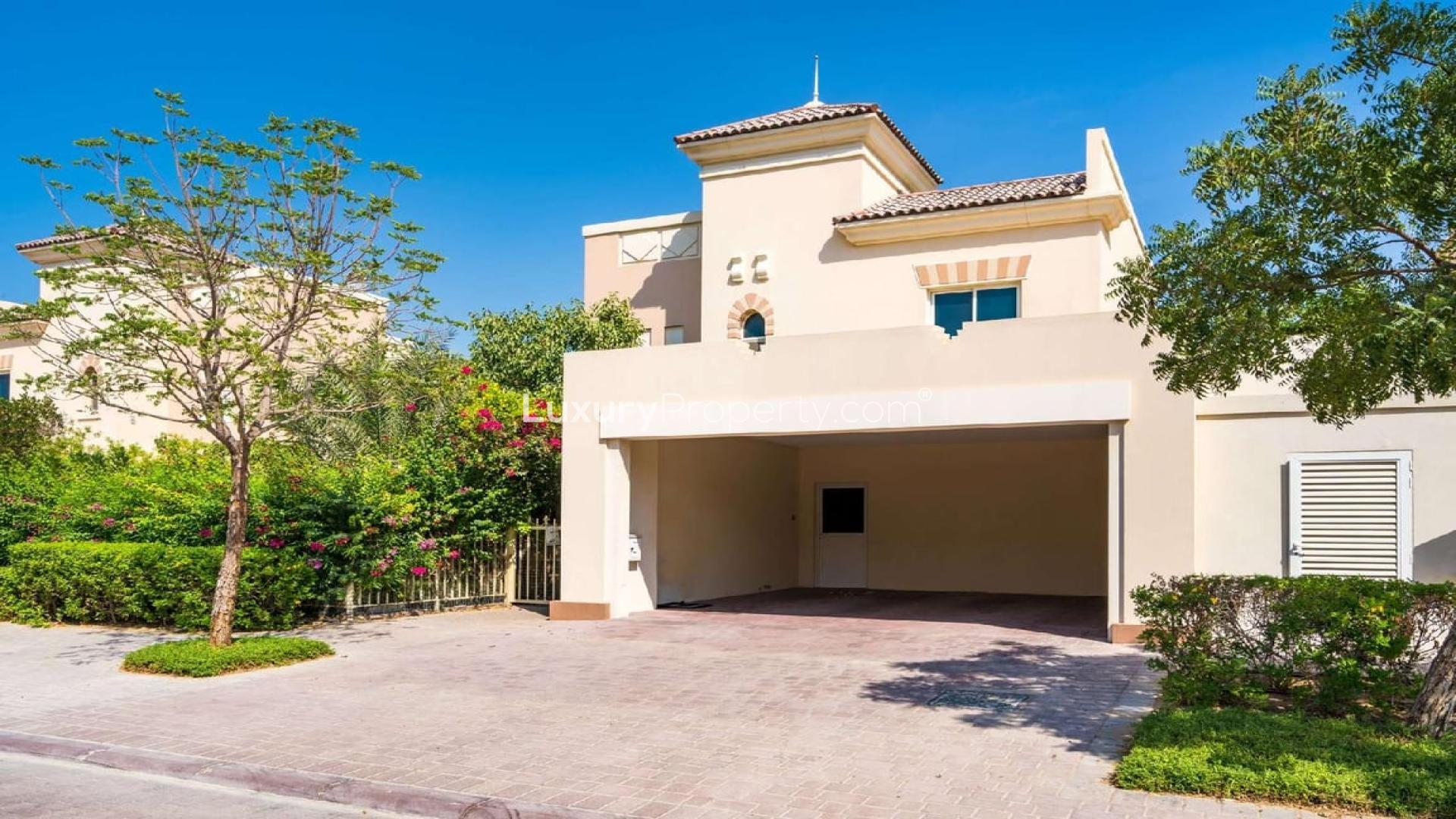 Four-bedroom villa exterior in Victory Heights, Dubai Sports City, with lush greenery