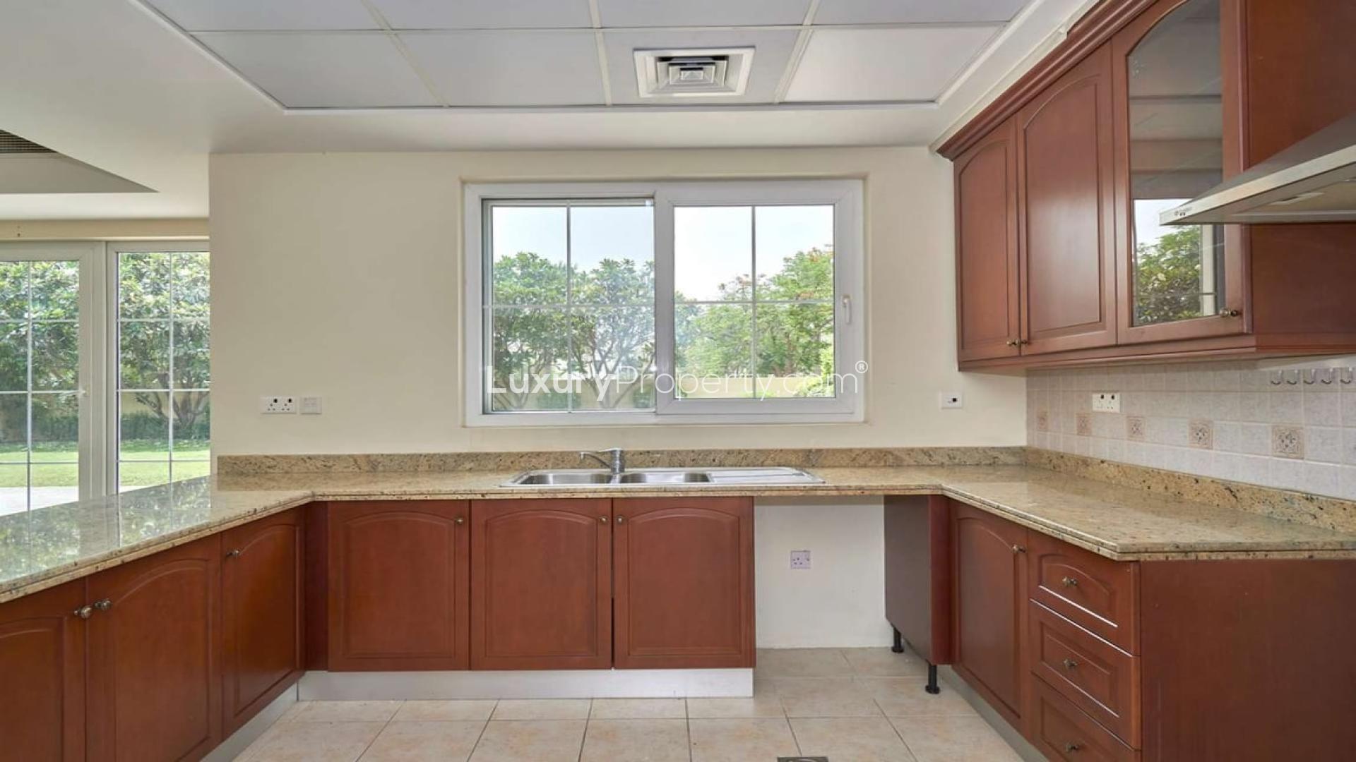 Modern kitchen with wooden cabinets and granite countertops in Mirador La Coleccion villa