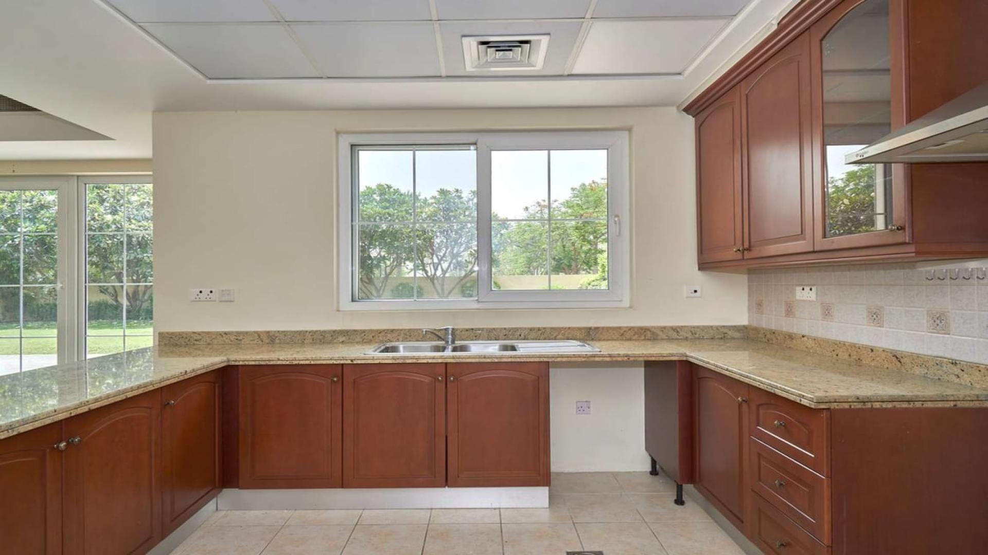 Modern kitchen with wooden cabinets and granite countertops in Mirador La Coleccion villa