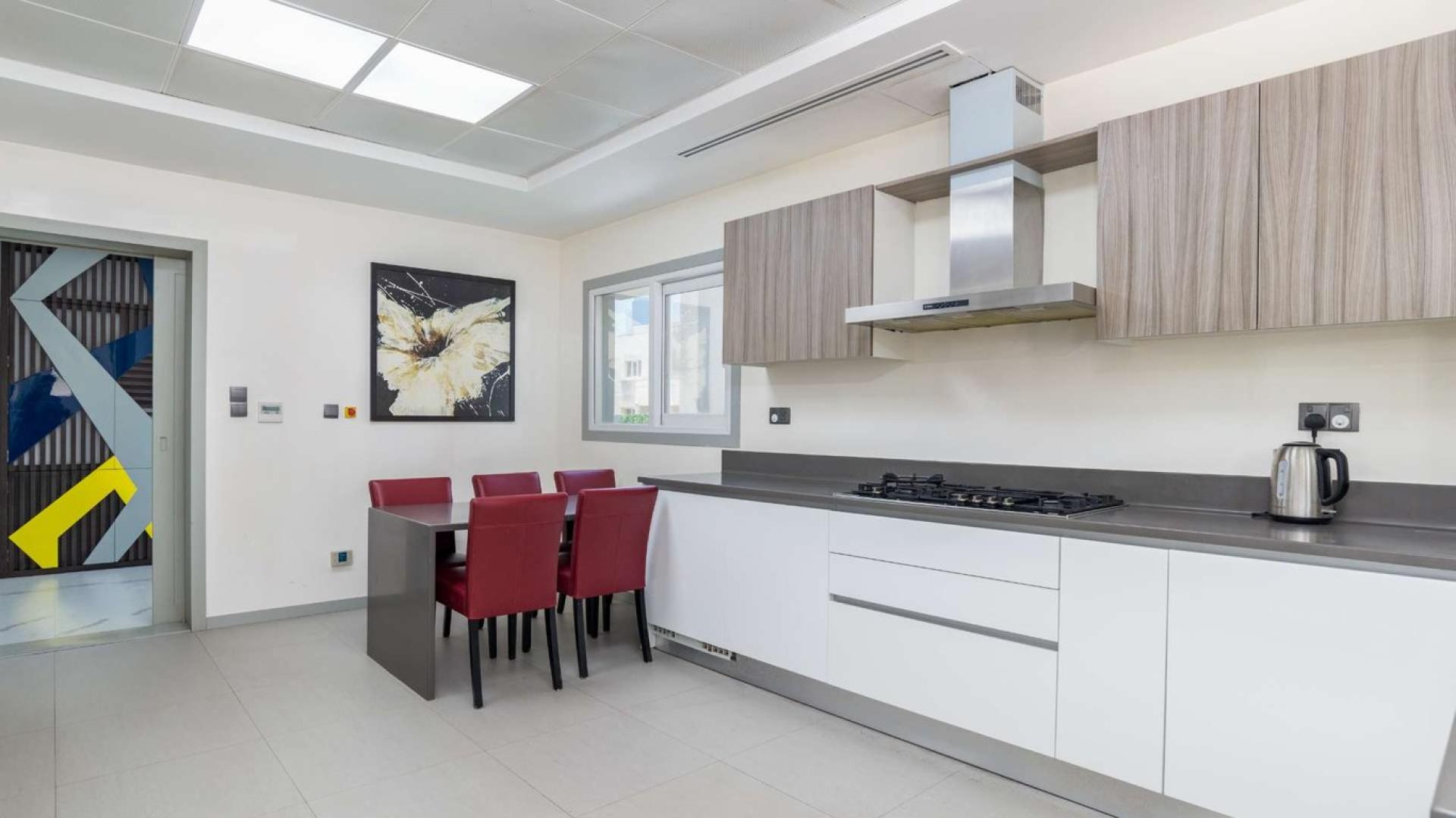"Elegant 4-bedroom villa exterior in Meadows 2, available for sale, Ref No: LP07423.",Modern kitchen in Meadows 2 villa with dining area and sleek cabinetry, LP07423
