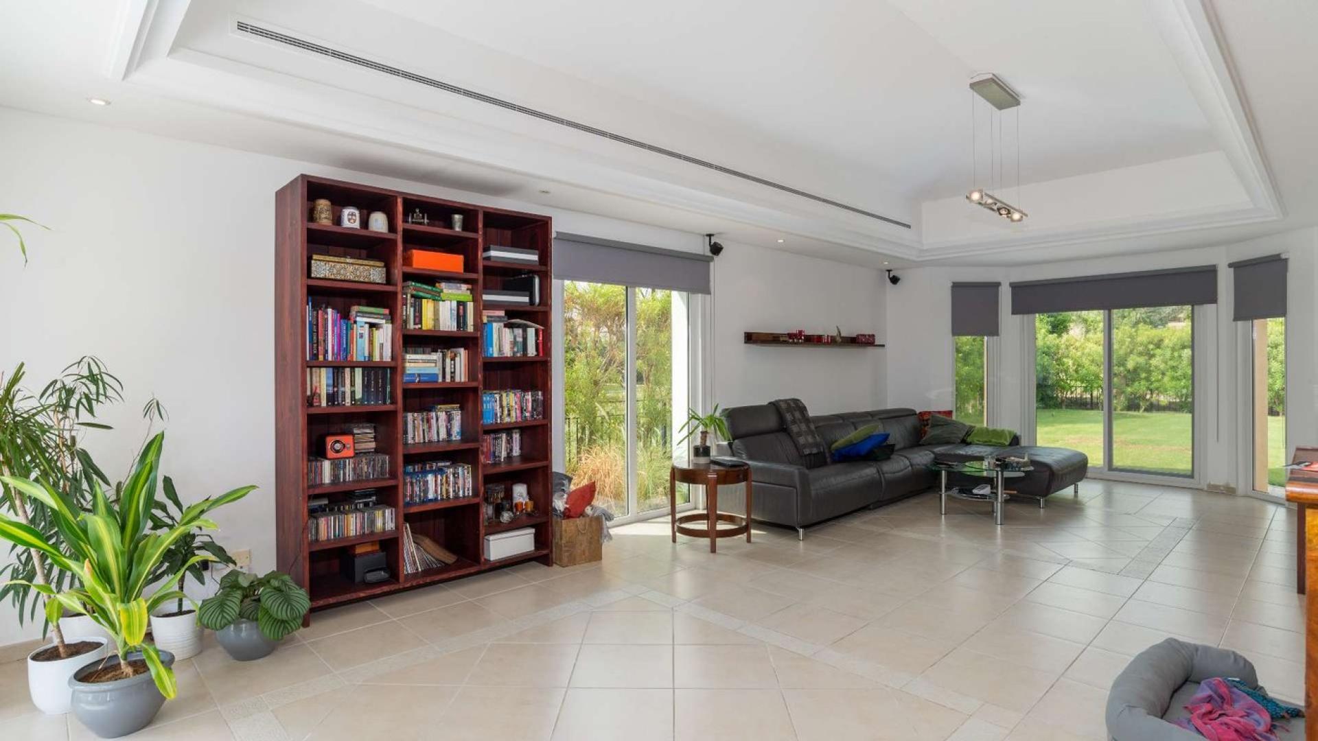 "Elegant villa entrance with red door in Green Community West, Western Dubai bungalow.",Living room in 4-bedroom bungalow, Green Community West, Western Dubai with garden view