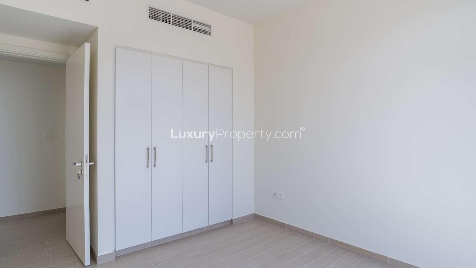 Luxurious villa poolside with sun loungers, umbrellas, and modern architecture in golf community