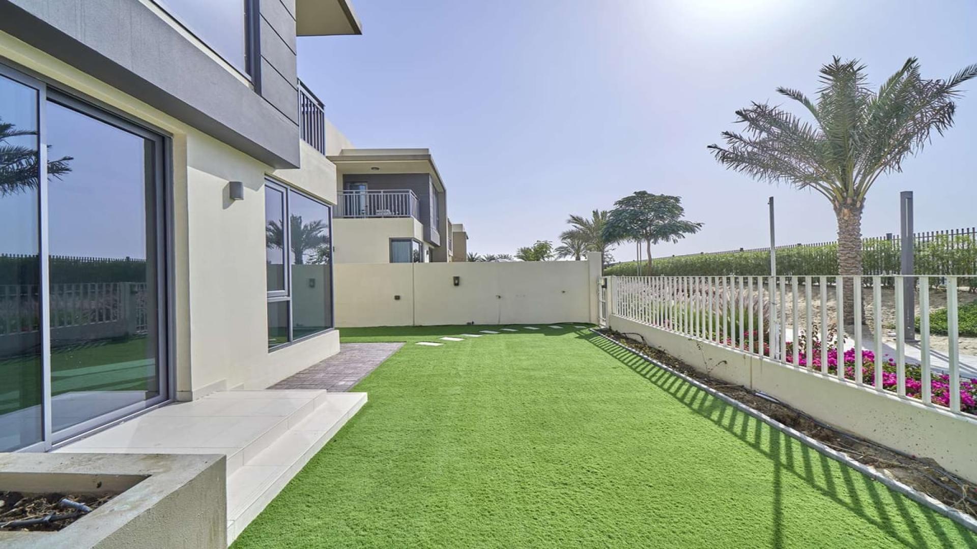 Exterior view of four-bedroom villa in Maple 2, Dubai Hills Estate with lawn and patio