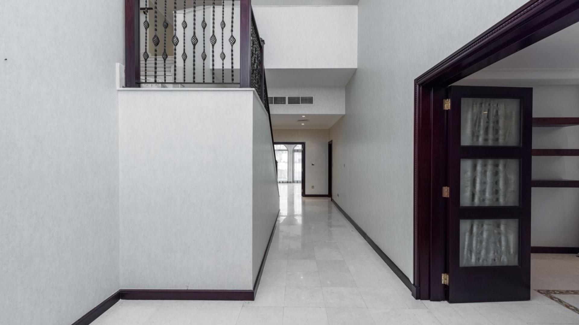 Spacious living room in Palm Jumeirah villa with large windows and garden views