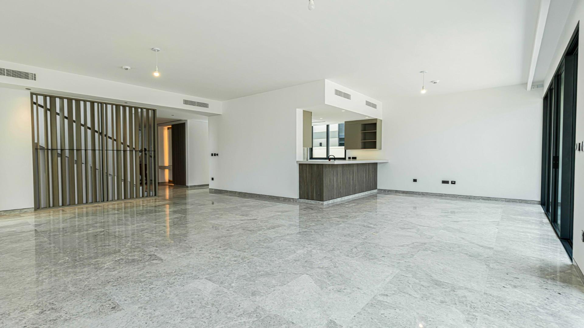 Spacious living area in Harmony Villa, Tilal Al Ghaf, featuring large windows and marble floors