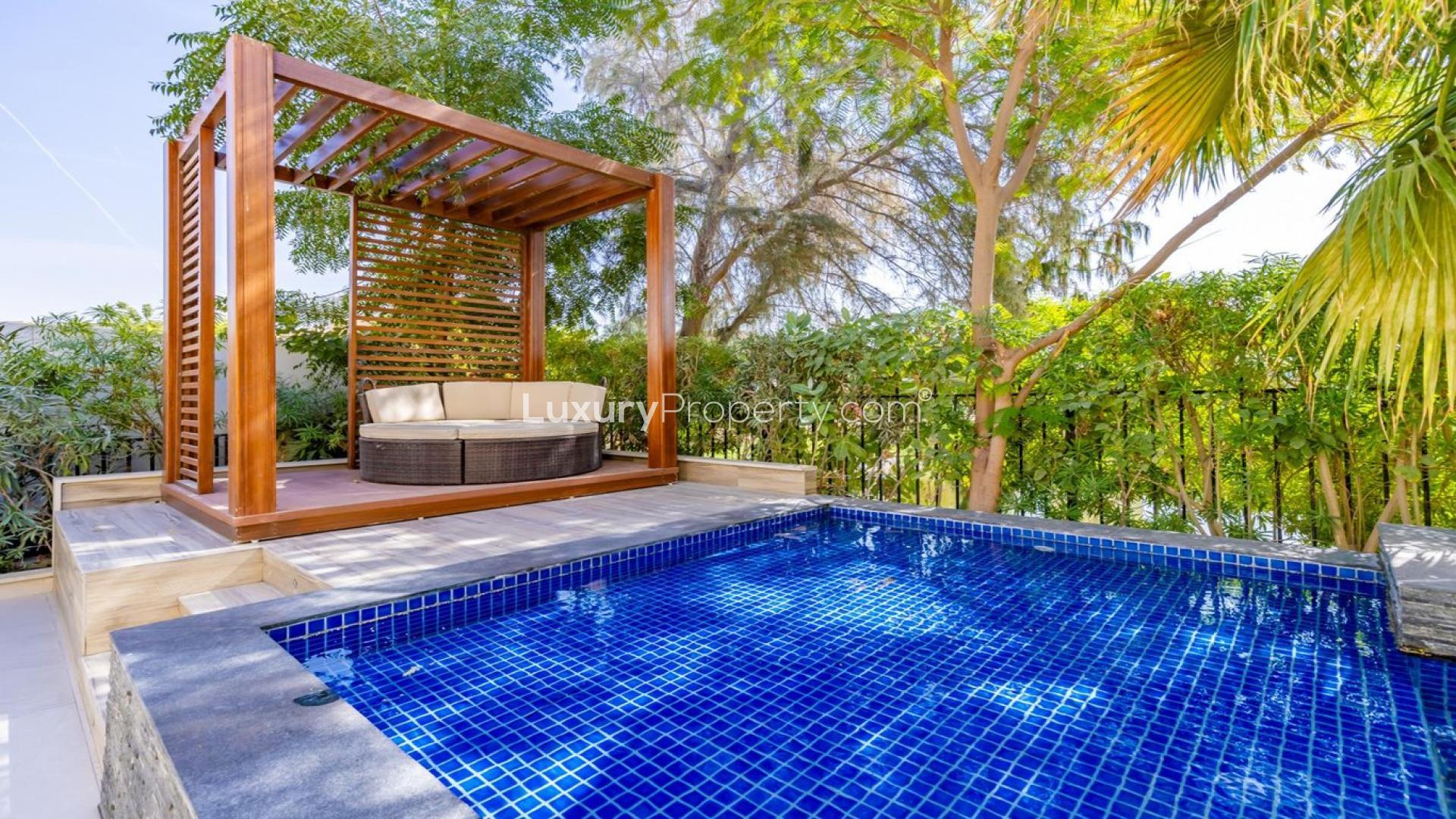 Luxurious villa with private pool in Jumeirah Islands, Dubai, surrounded by lush greenery