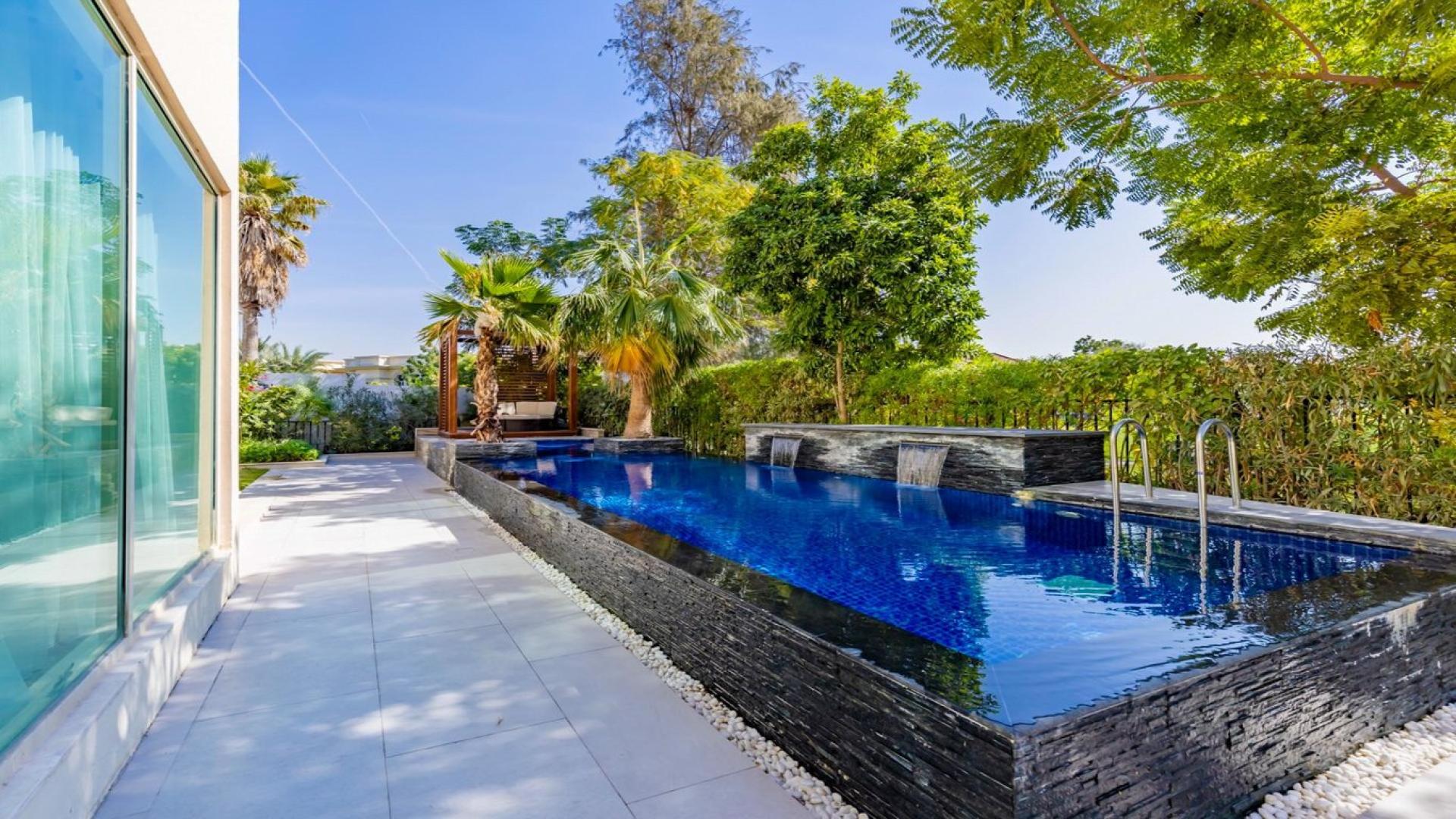 Luxurious 4-bedroom villa exterior with landscaped garden in Jumeirah Islands, Dubai for sale