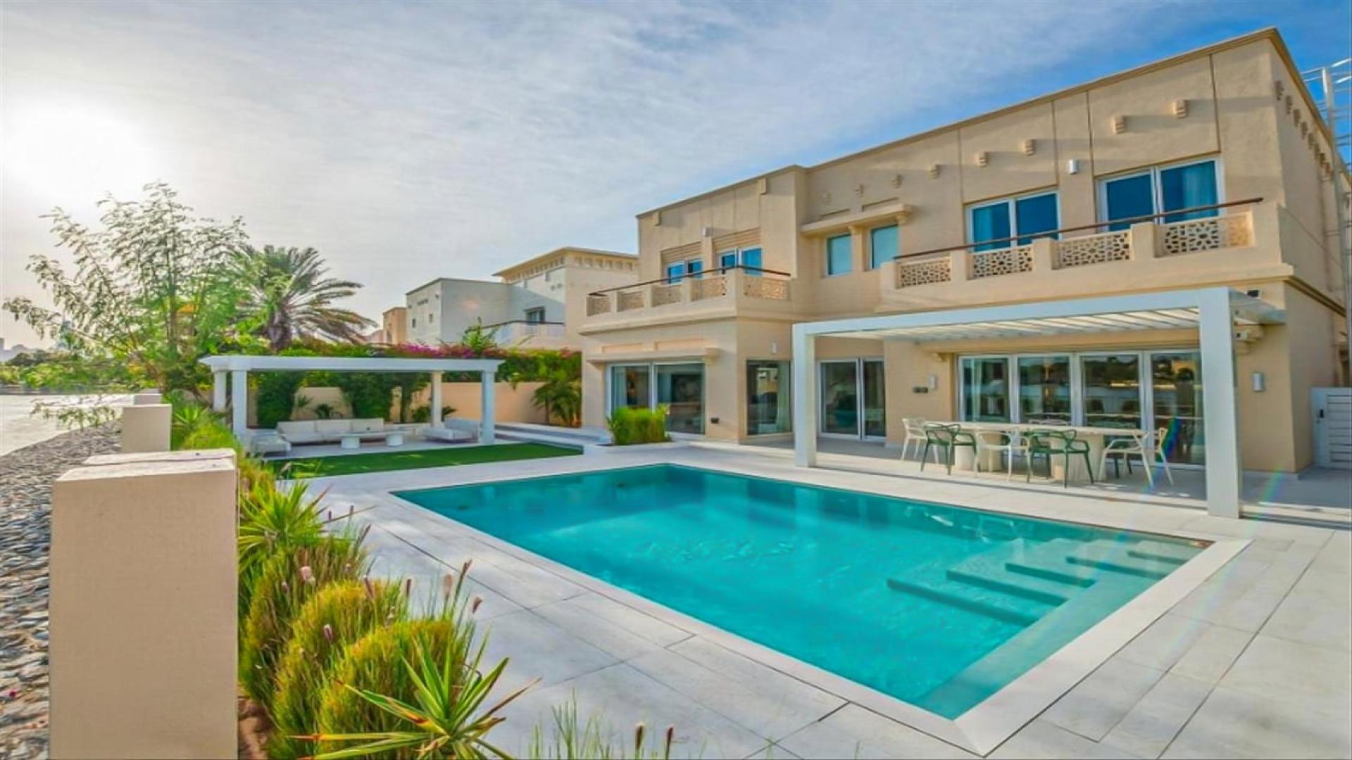 Renovated villa interior with modern decor, open living area, and pool view in The Lakes