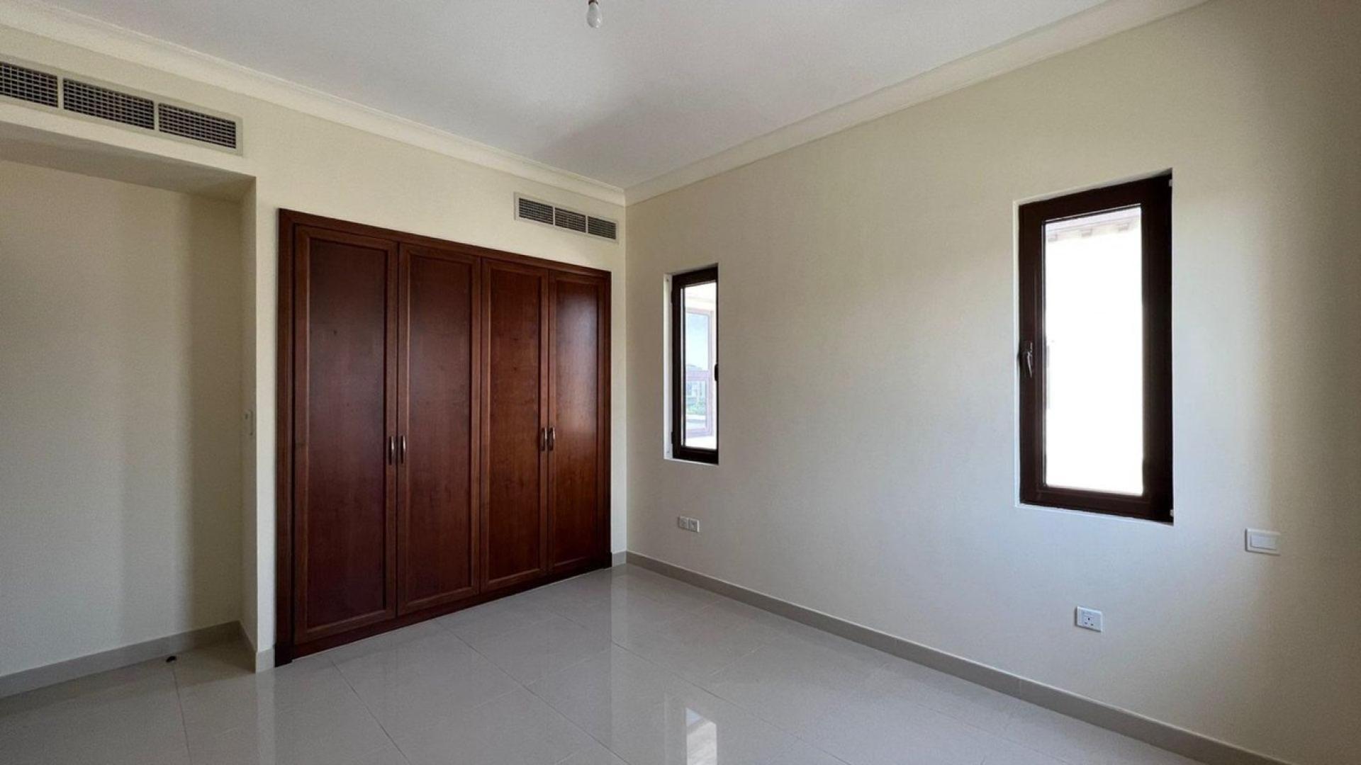 Empty bedroom with wooden built-in wardrobes in Rosa Villa, Arabian Ranches 2