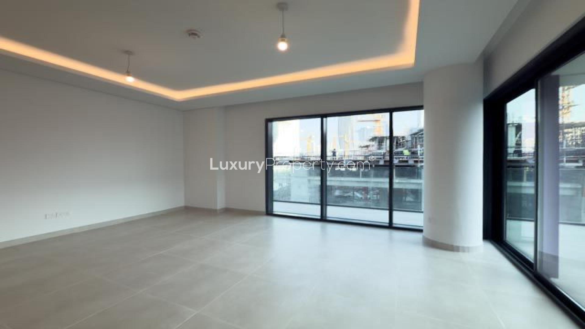 Empty bedroom in Dubai Creek Harbour apartment, featuring built-in wardrobe and tiled floor