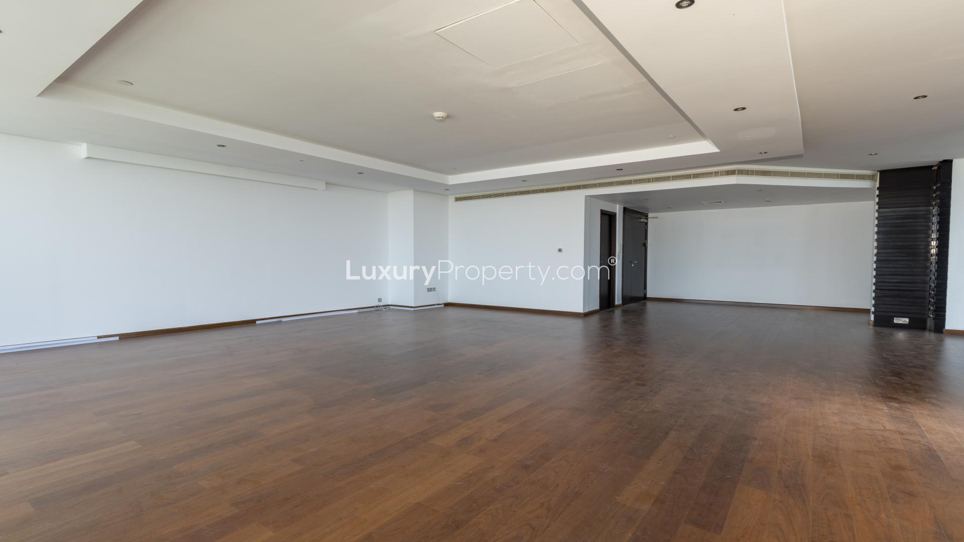 Spacious living room with wooden floors and large windows in 4-bedroom duplex, 23 Marina