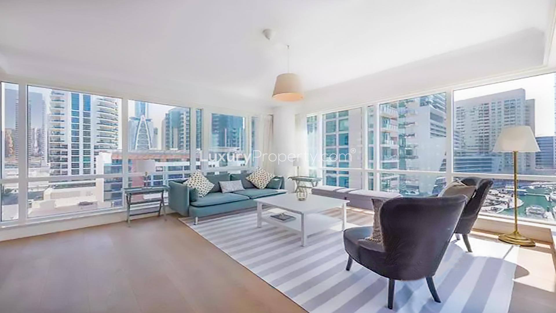 "Stunning Dubai Marina view from Al Majara apartment balcony with yachts and skyscrapers.",Furnished apartment living room with marina views in Al Majara, Dubai Marina for rent