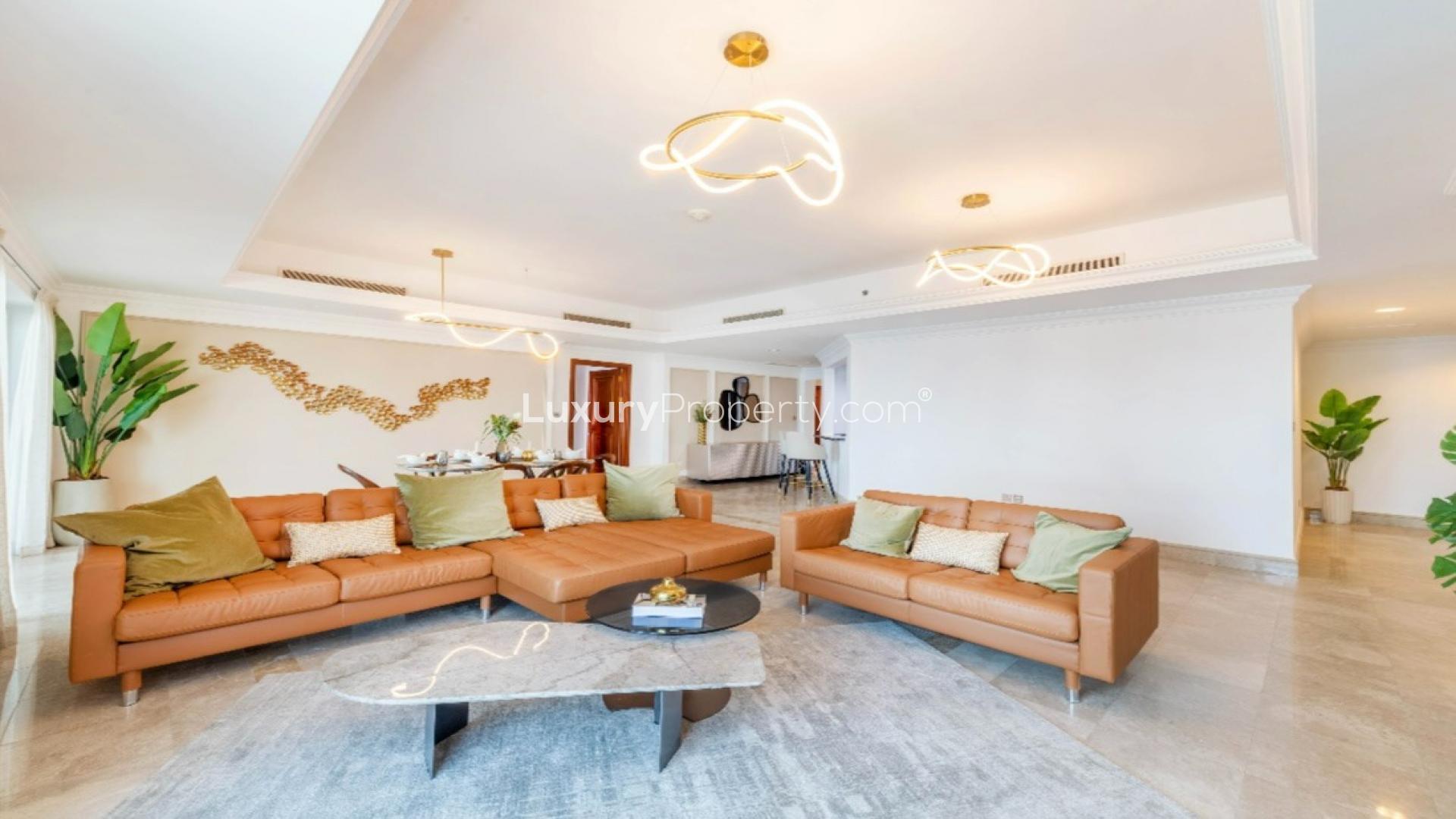 "Spacious balcony with seaview at Palm Jumeirah apartment, Fairmont South, available for rent.",Luxurious living room in Fairmont South seaview apartment, Palm Jumeirah, with modern decor
