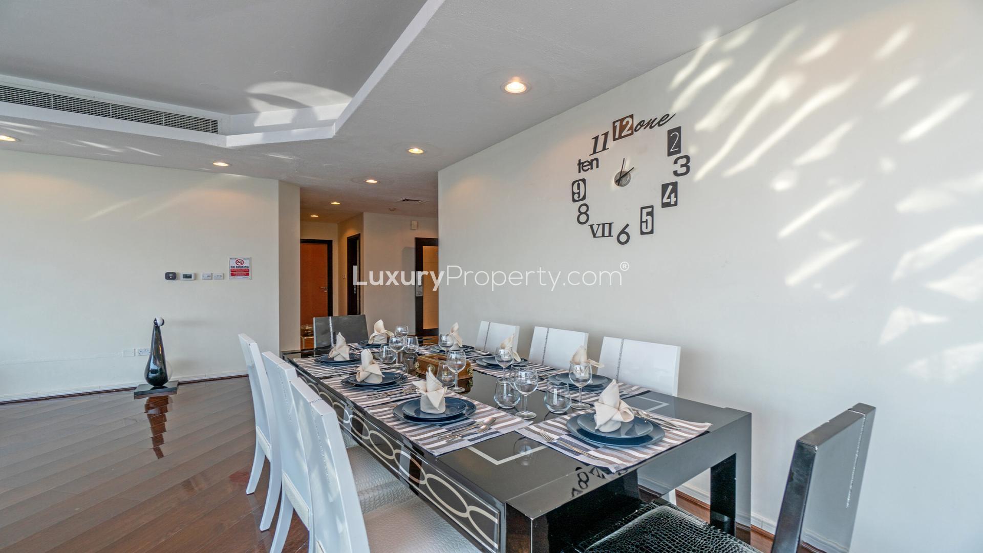 Stylish living room in Dubai Marina apartment with city views, elegant decor, and dining area