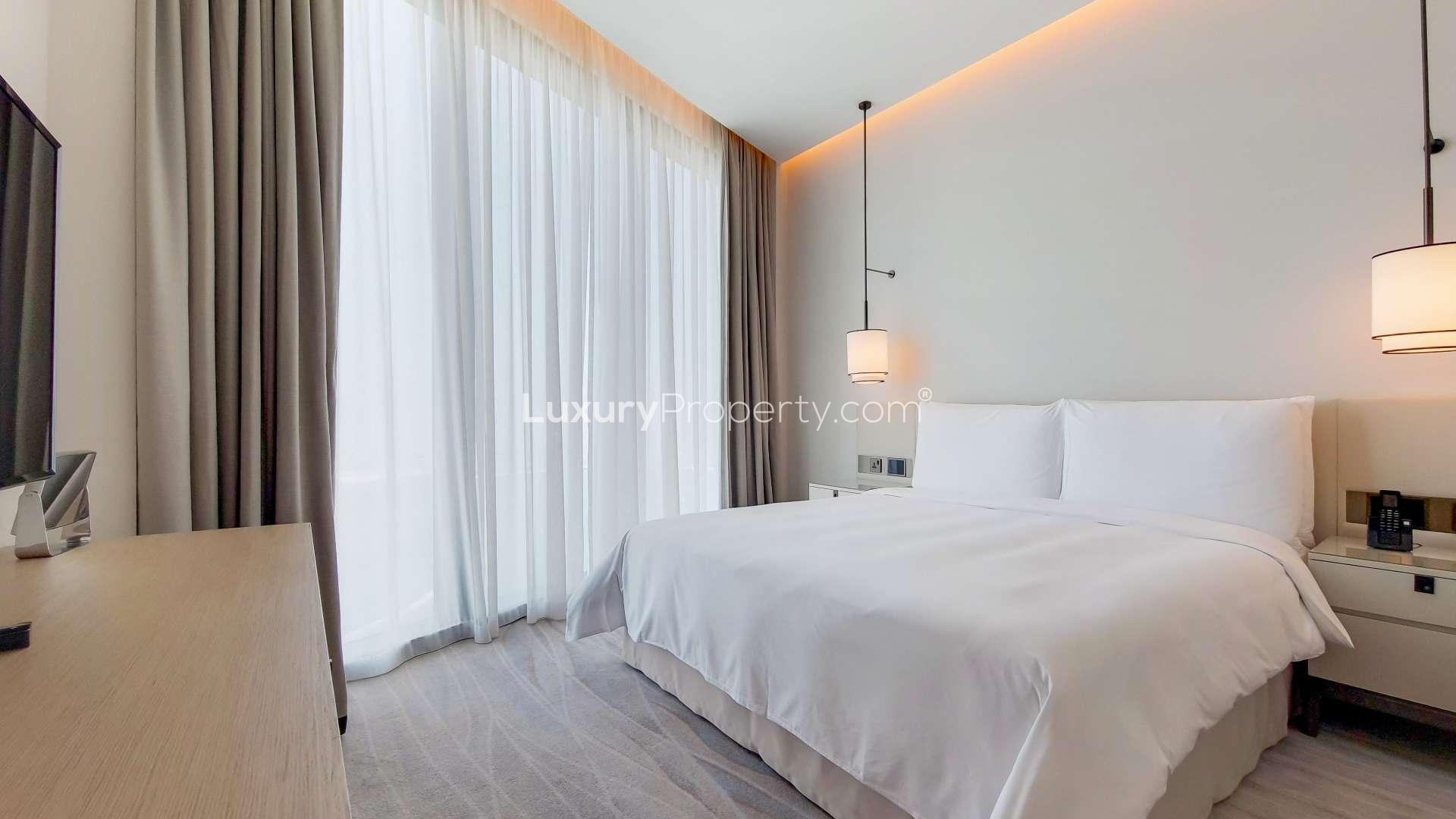 High-floor Jumeirah Beach Residence apartment bedroom with sea views, modern decor, large windows