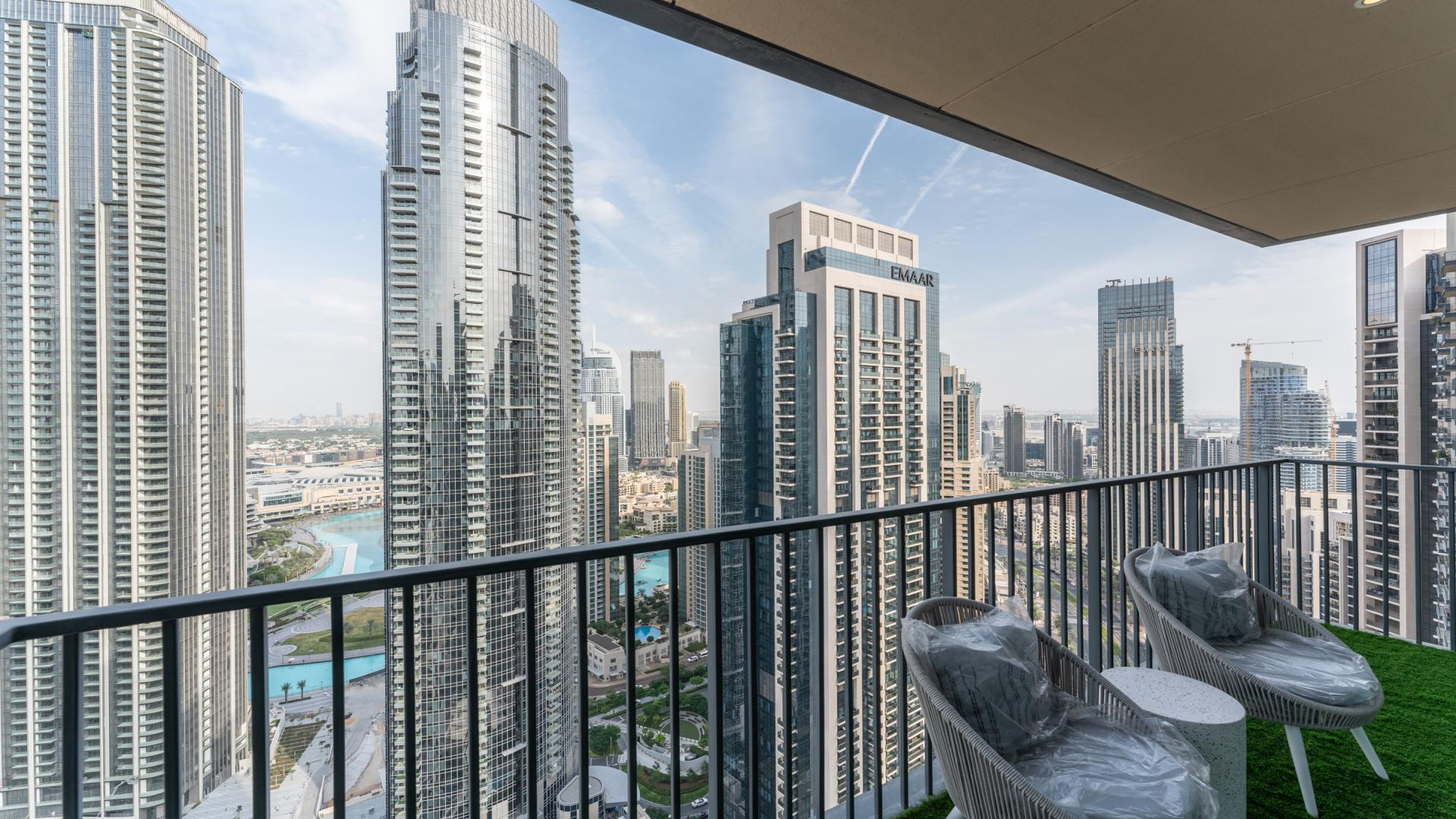Modern living room with large windows, stylish decor, and Downtown Dubai skyline view