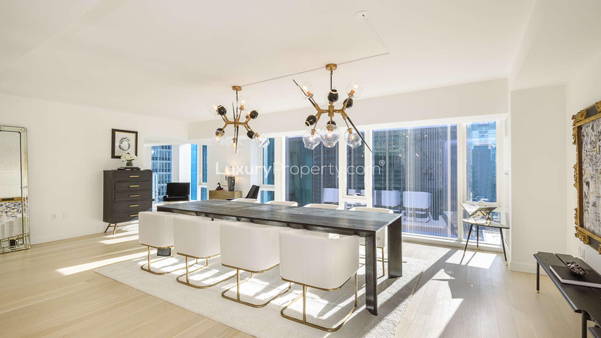 Luxurious dining area in Manhattan apartment, modern chandelier and large windows