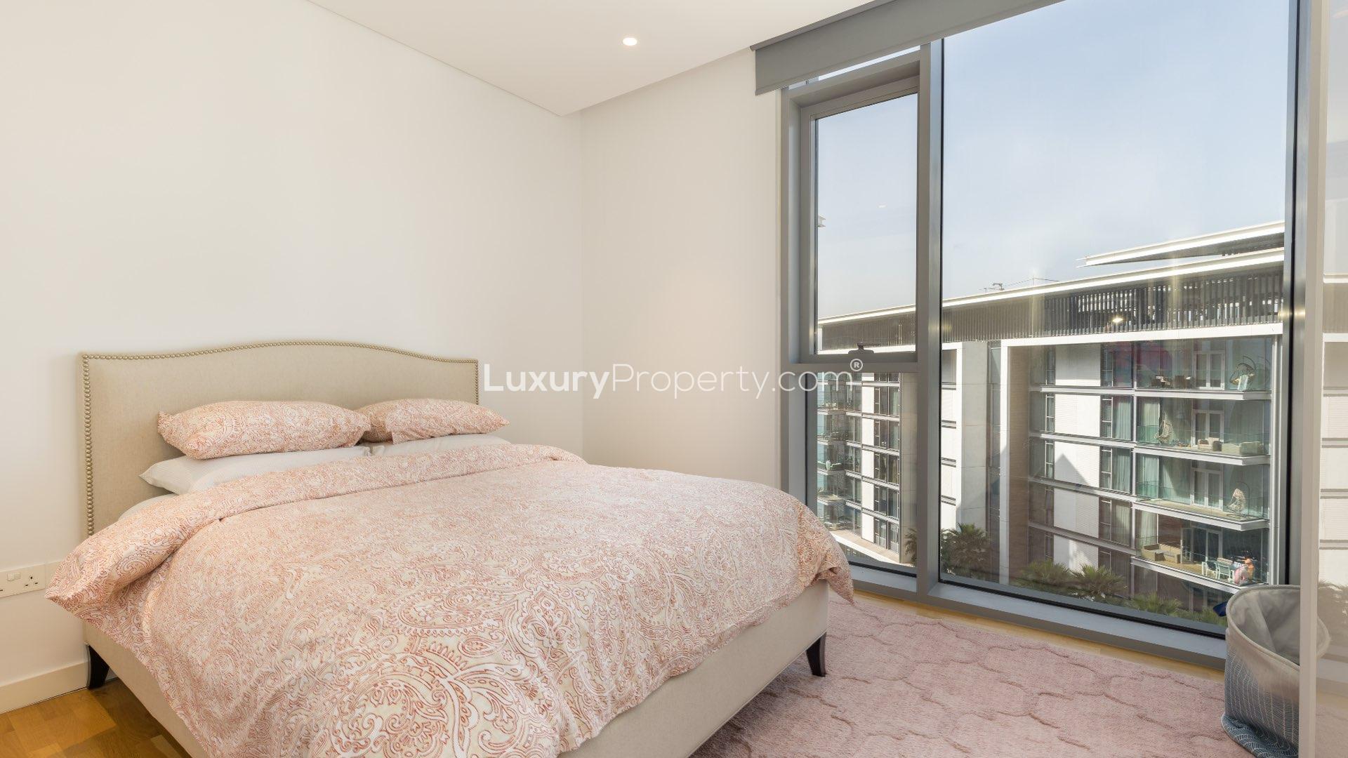 Exterior view of Bluewaters Island apartment complex with ocean backdrop and lush landscaping