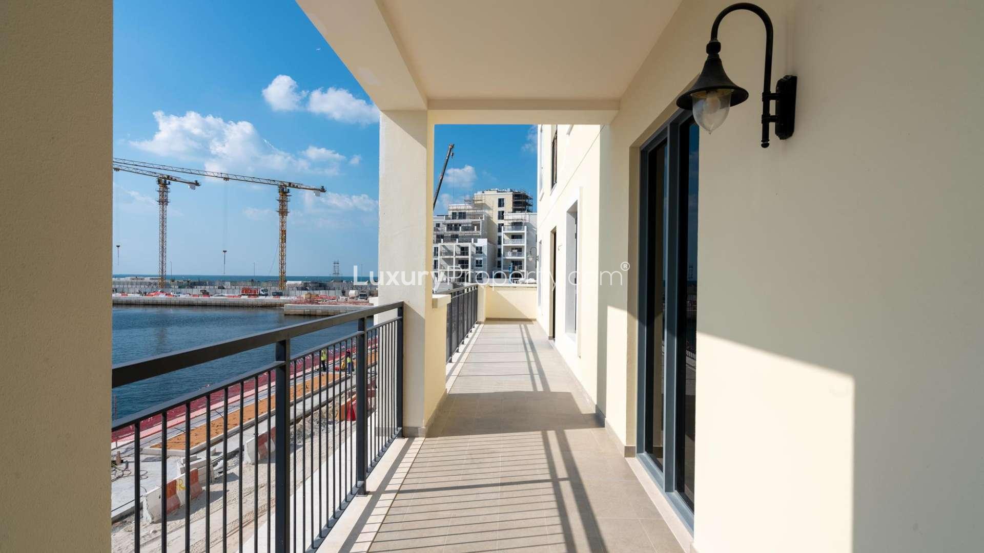 Empty living room with ocean view through large windows in La Voile, Jumeirah apartment