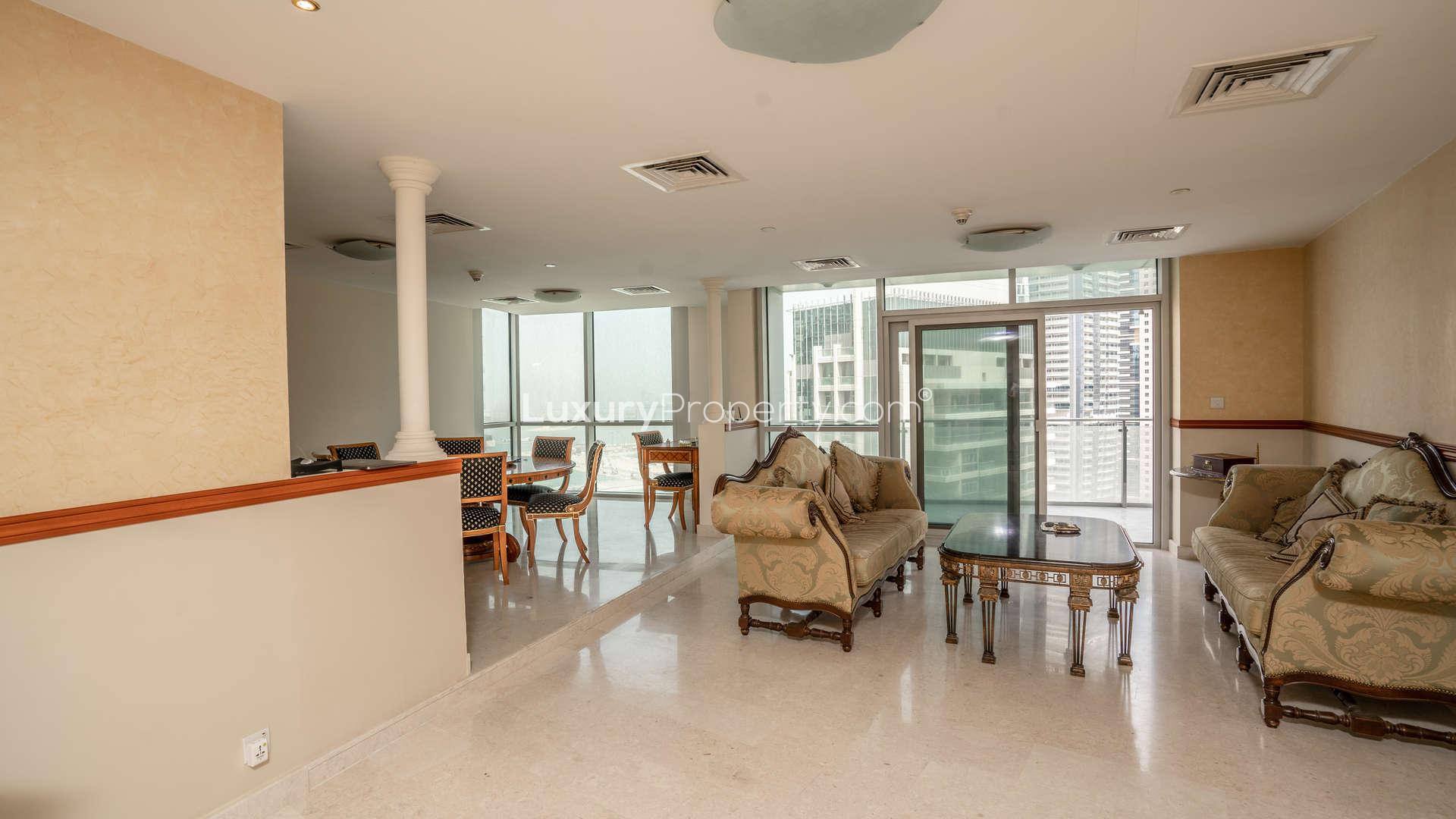 "Elegant living area in 4-bedroom duplex penthouse, Dubai Marina, with marina views and balcony.",Luxurious living room in Dubai Marina duplex penthouse with elegant furnishings and city views