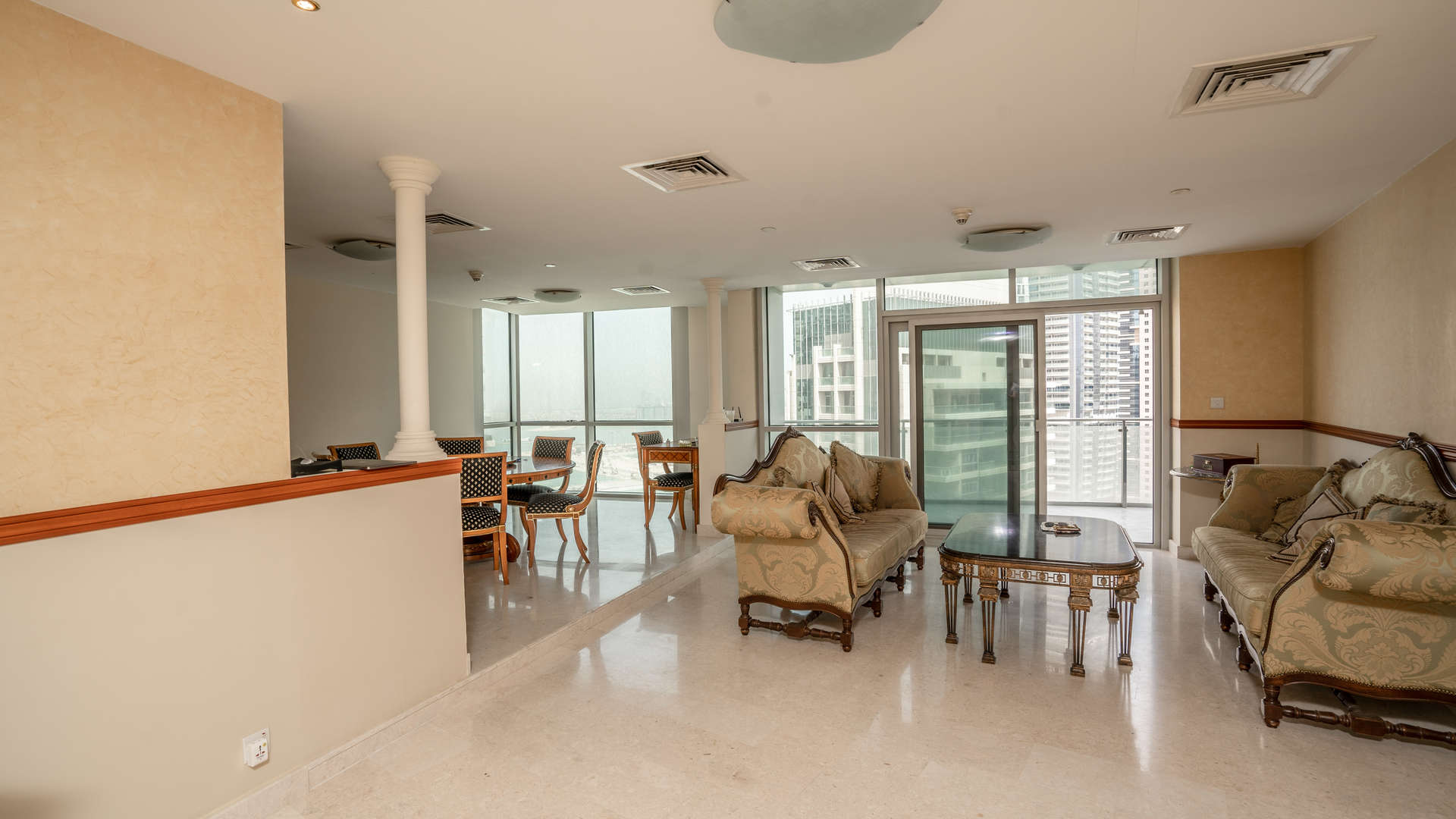 "Elegant living area in 4-bedroom duplex penthouse, Dubai Marina, with marina views and balcony.",Luxurious living room in Dubai Marina duplex penthouse with elegant furnishings and city views