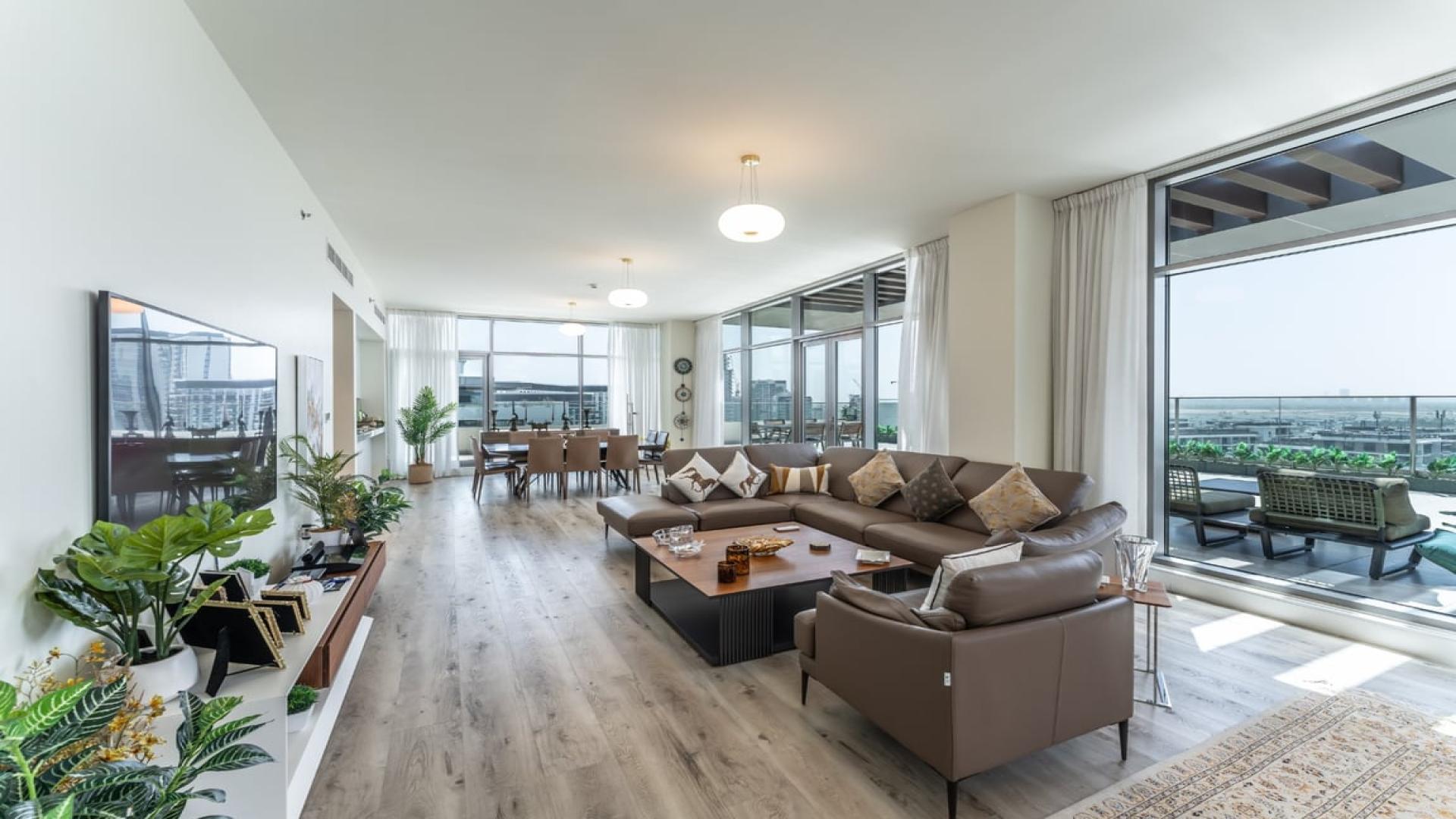 Luxurious penthouse living room with modern decor, large windows, and terrace in Dubai Hills Estate