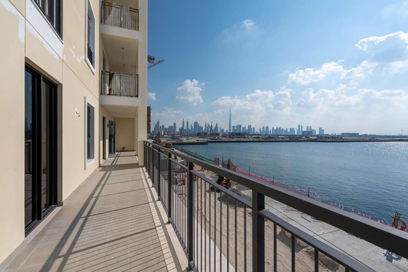 La Mer community entrance with palm trees, Jumeirah, near four-bedroom waterfront apartment