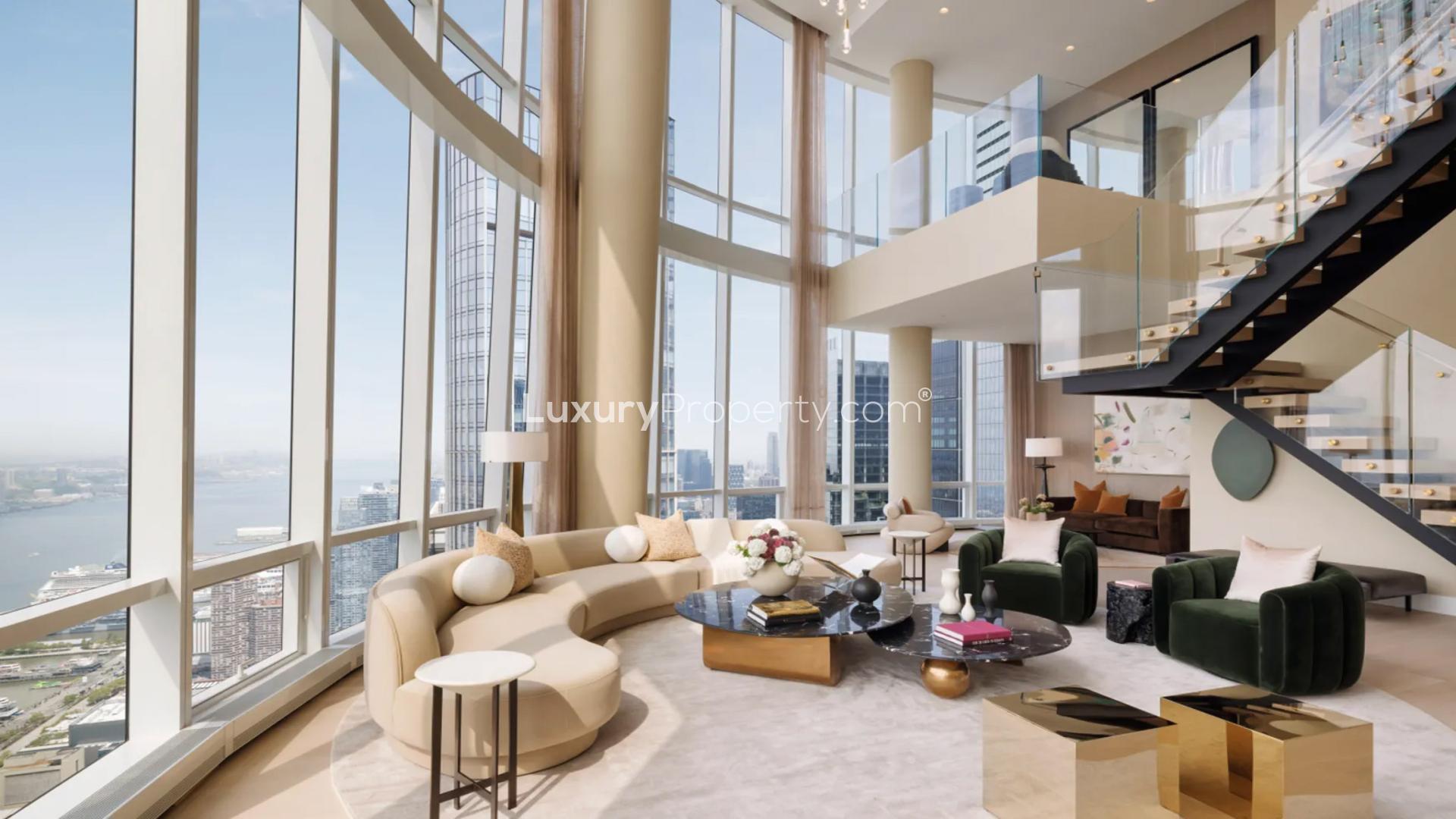 Luxurious double-height penthouse living room with city views, modern decor, and fireplace