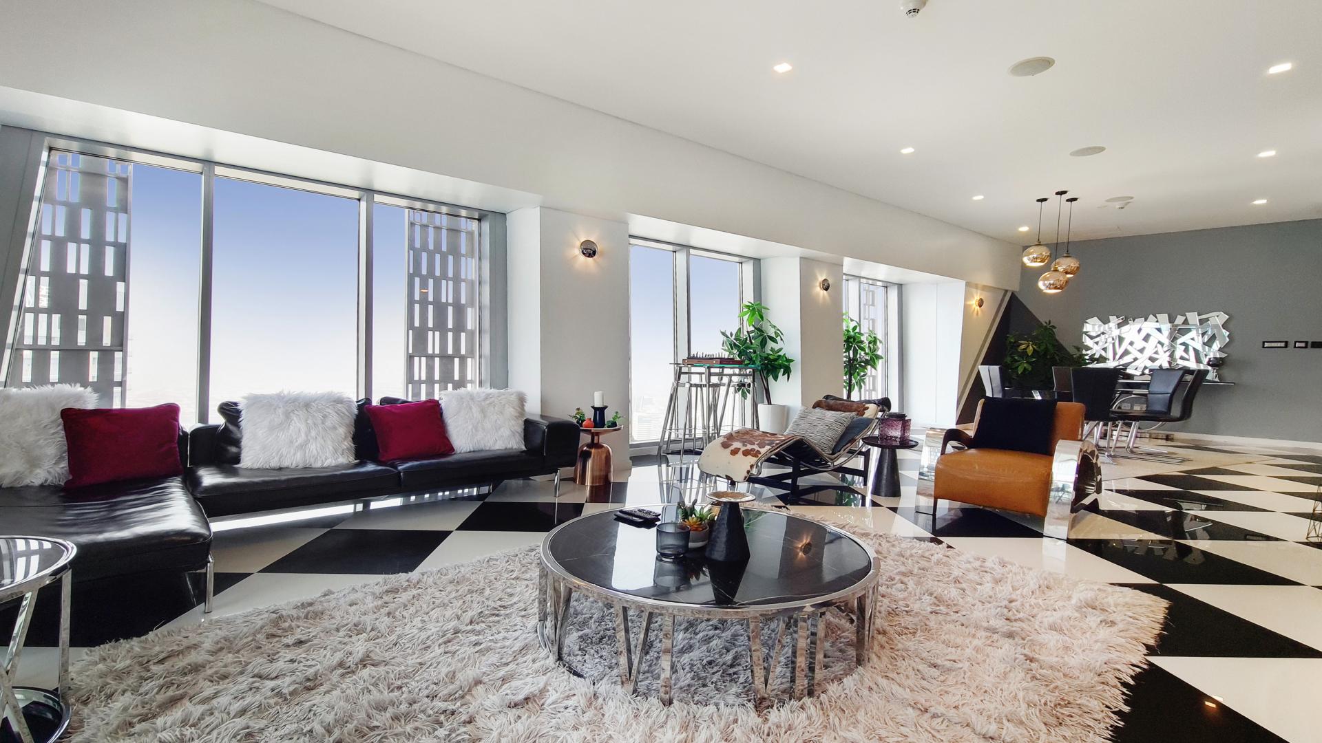 Luxurious living room in Cayan Tower penthouse, Dubai Marina, with modern decor and marina views