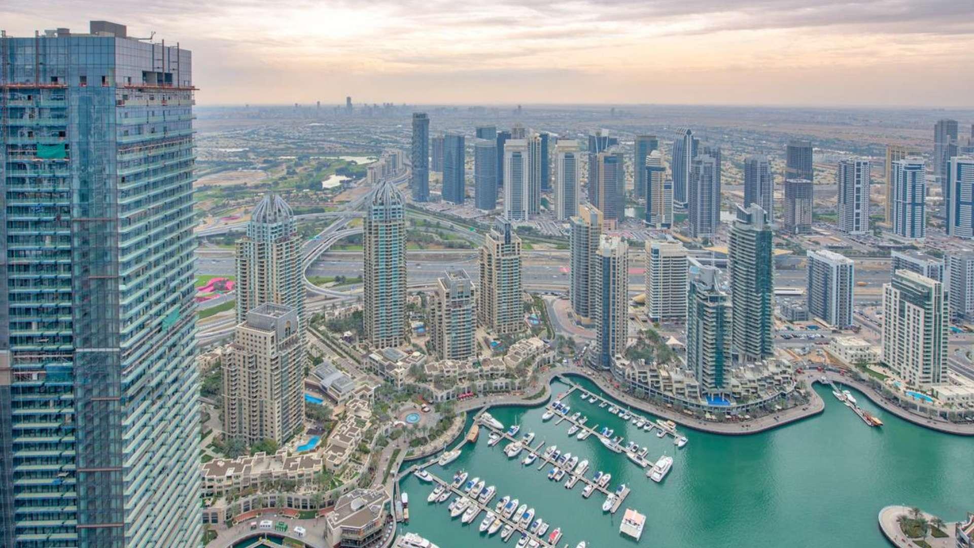 Modern kitchen in luxurious Cayan Tower penthouse, Dubai Marina, featuring sleek design and appliances
