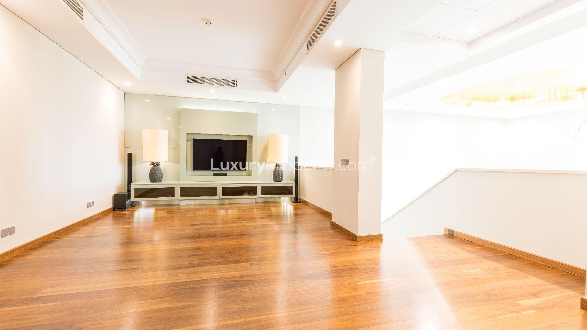 Luxurious penthouse living room with wooden stairs and balcony view in Shoreline Residences