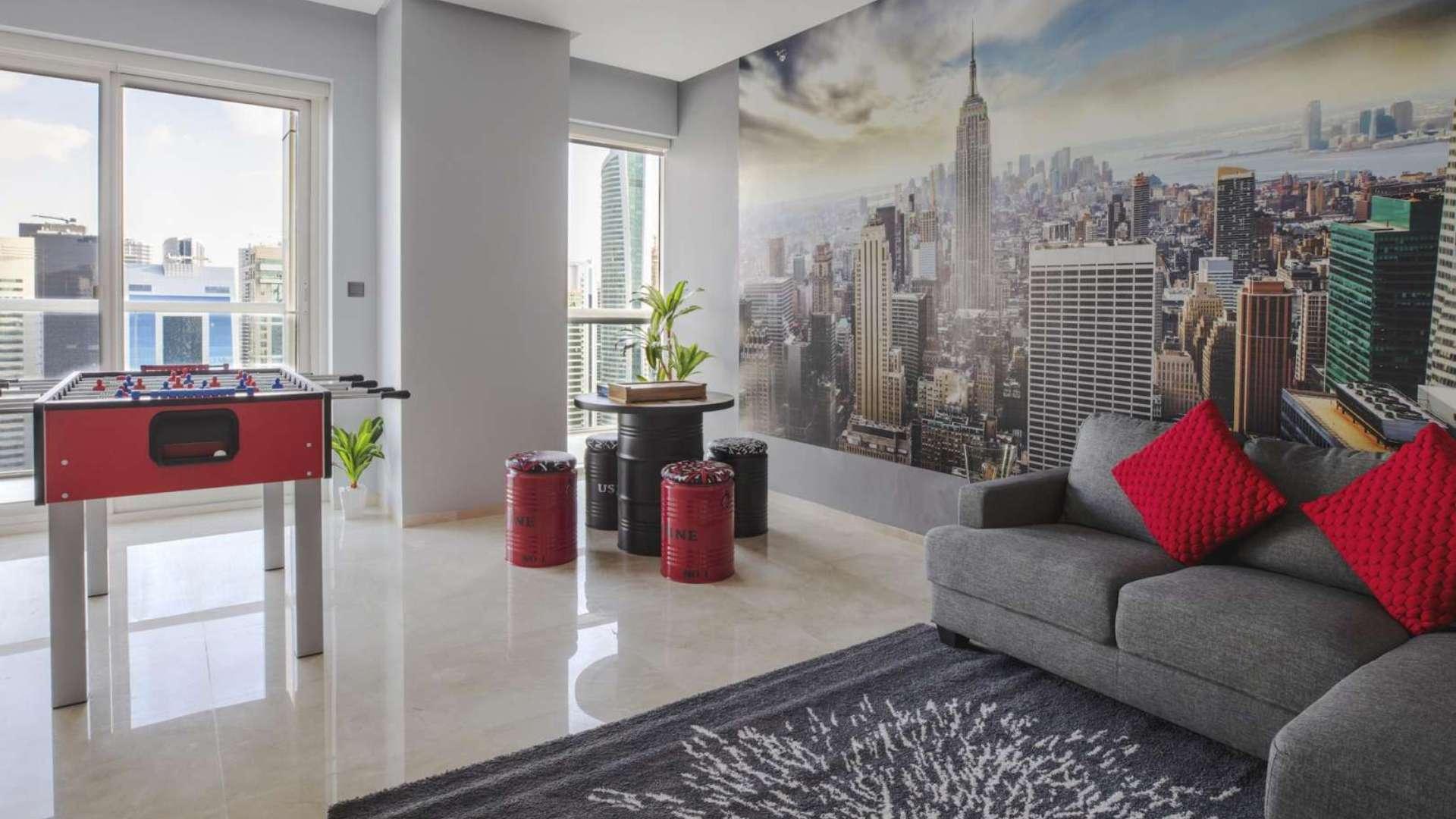 Stylish living area in furnished Dubai Marina penthouse with cityscape wall art and modern decor