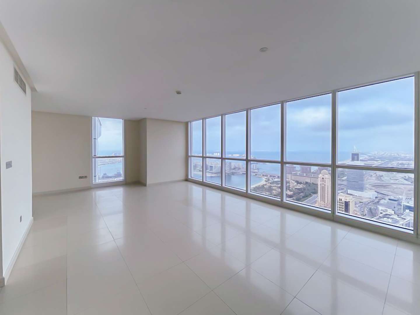 Spacious penthouse living area with large windows offering stunning Dubai Marina views