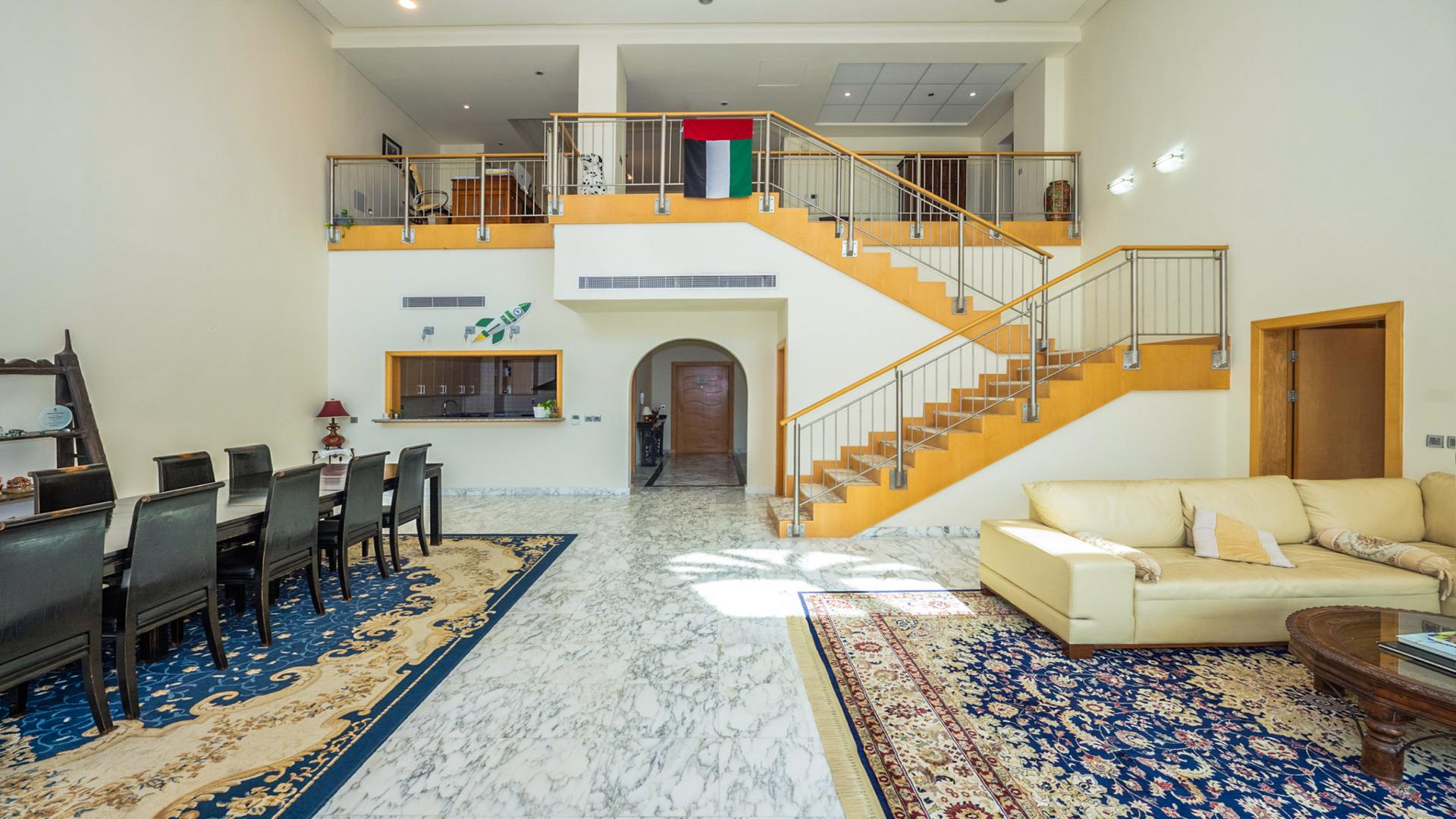 "Spacious balcony view from Shoreline Apartments penthouse, Palm Jumeirah, with city skyline.",Luxurious living room in Palm Jumeirah duplex penthouse, marble floors, elegant staircase, spacious layout
