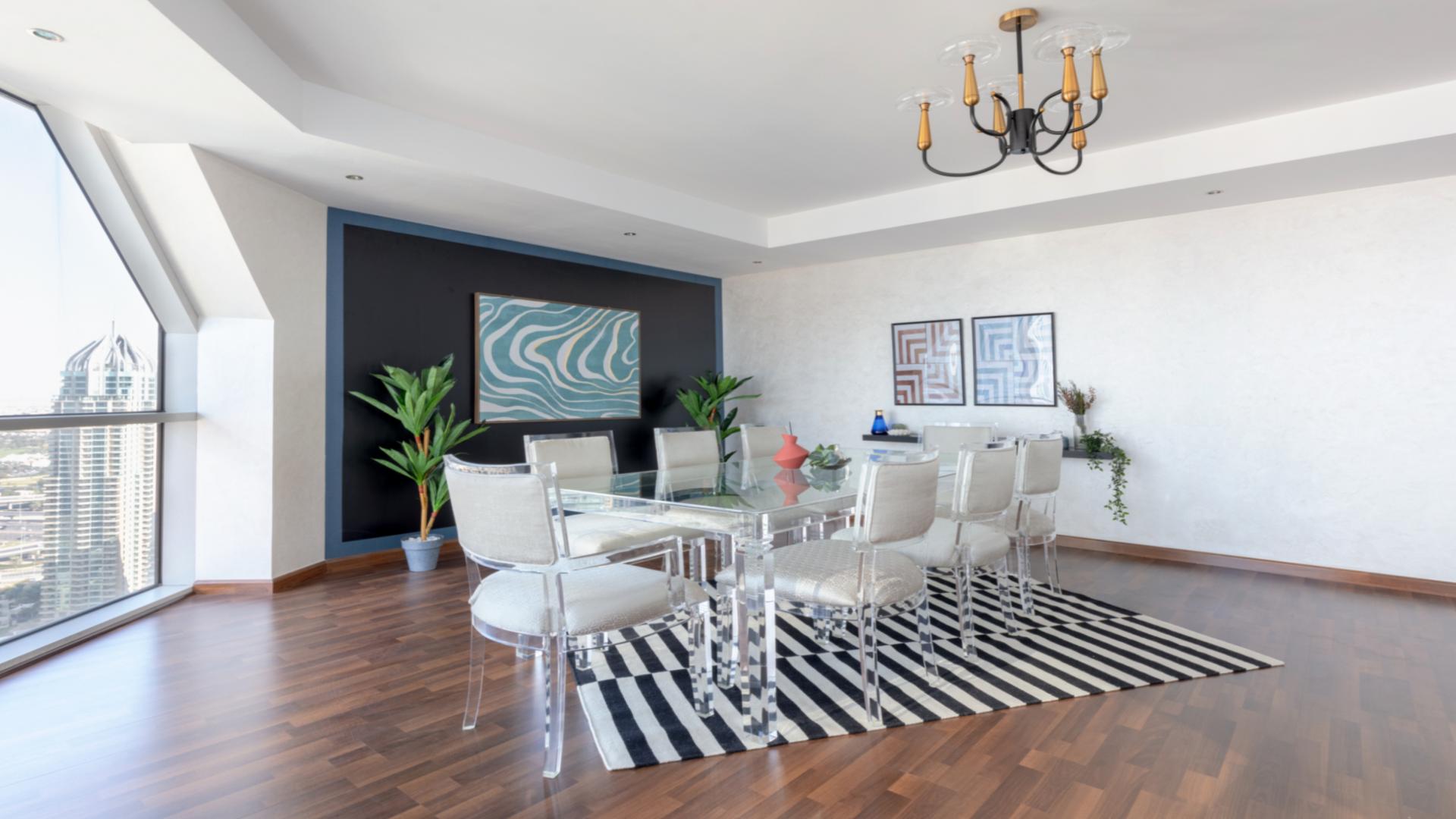 Bright living room in Dubai Marina penthouse with modern furniture and wooden flooring