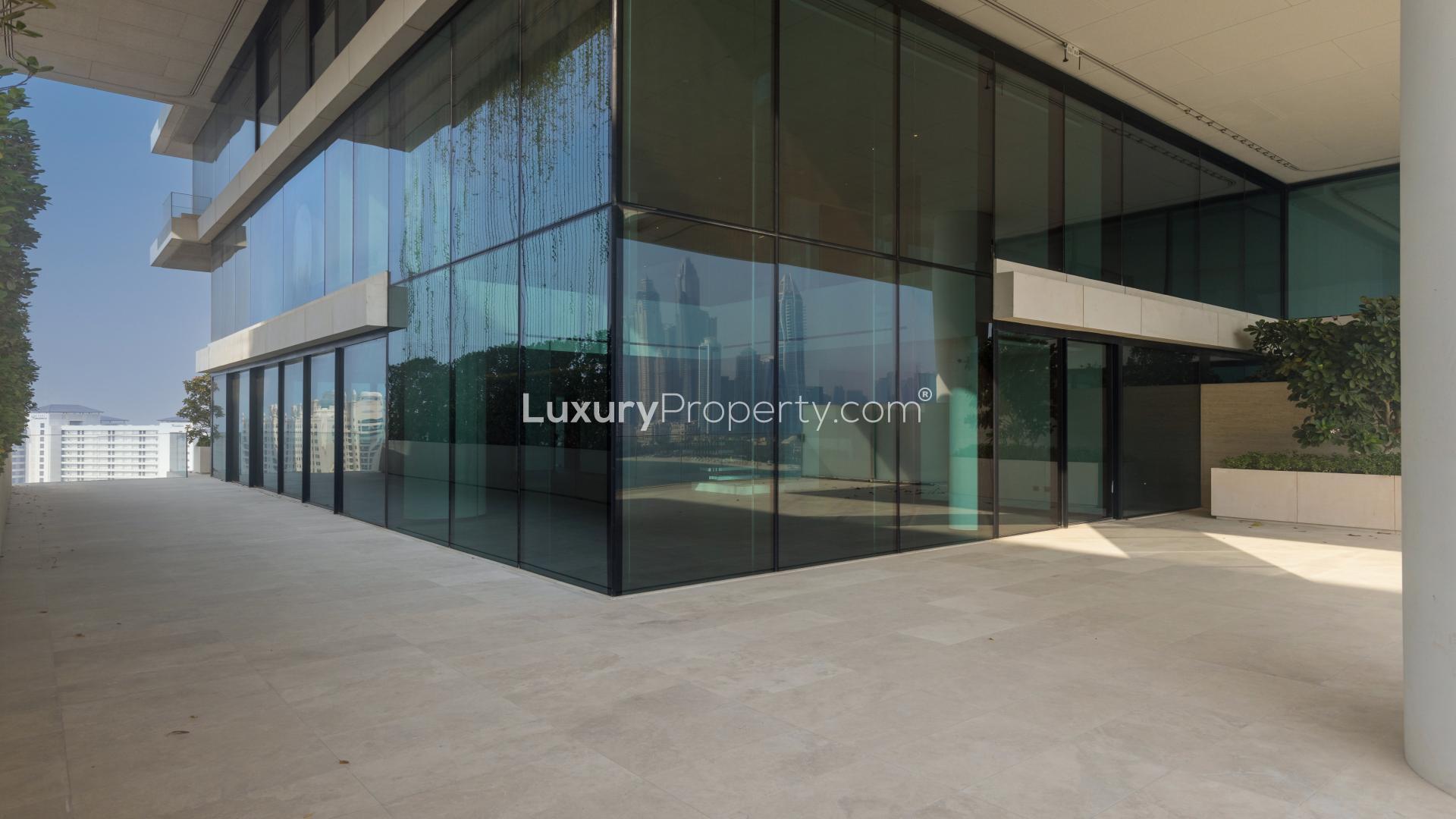 Penthouse terrace with stunning Palm Jumeirah skyline view, featuring waterfront and lush greenery