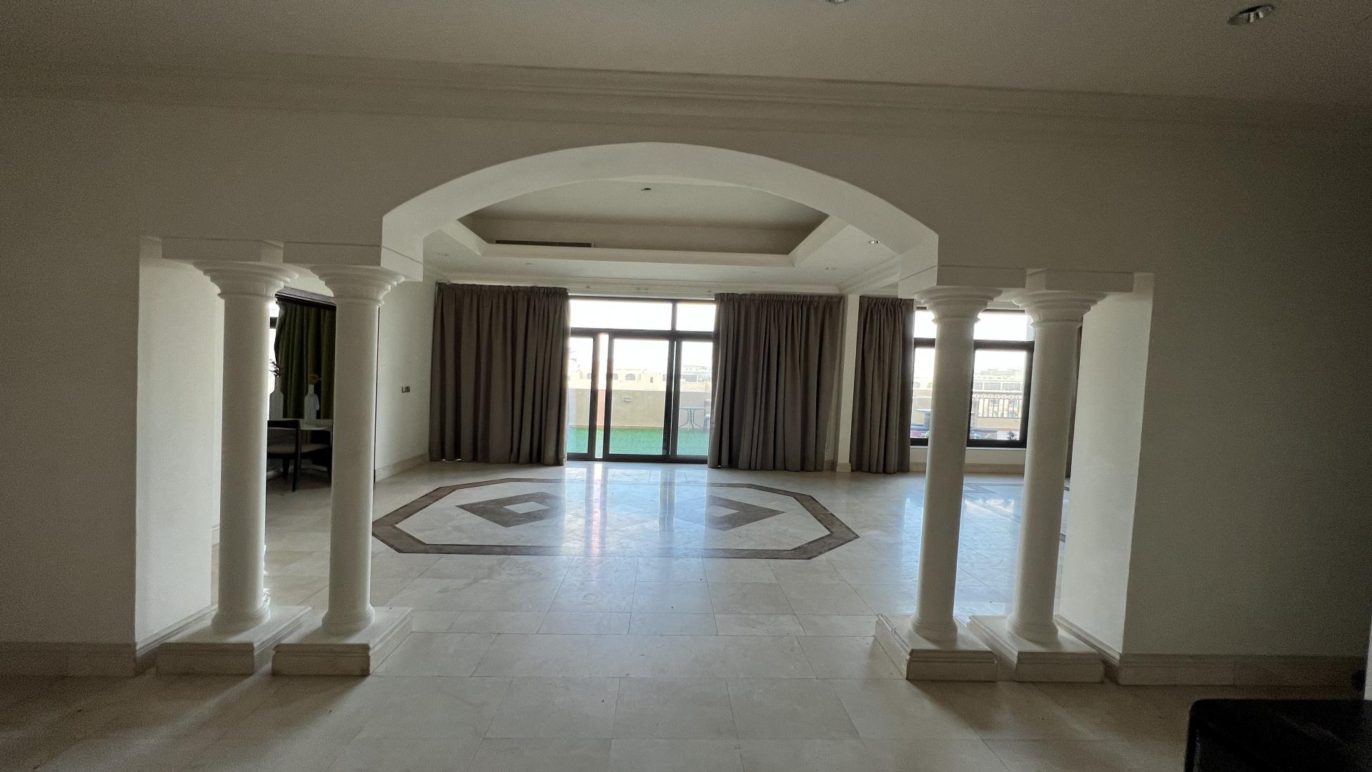 Spacious terrace with artificial grass and seating, offering cityscape views at Fairmont Palm Residence