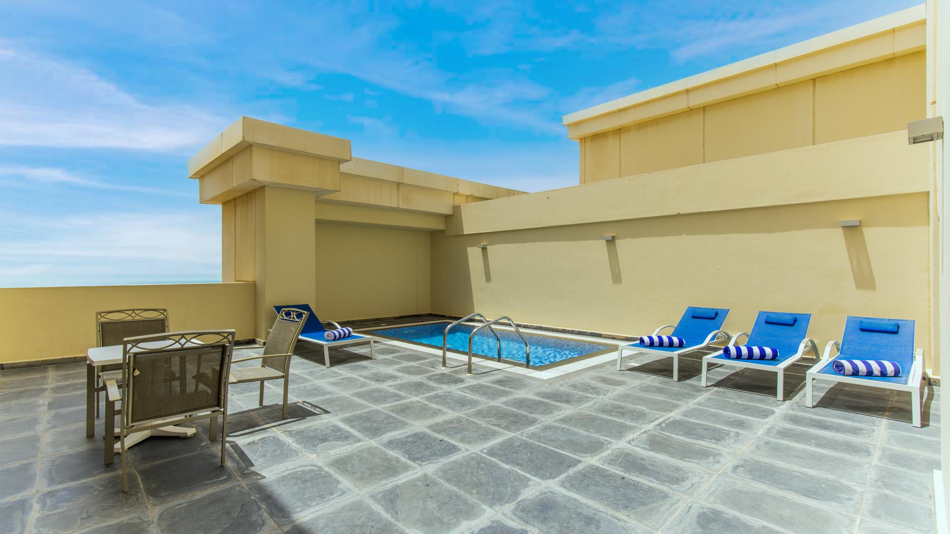 Luxurious living room in Jumeirah Beach penthouse with plush sofas and pool table